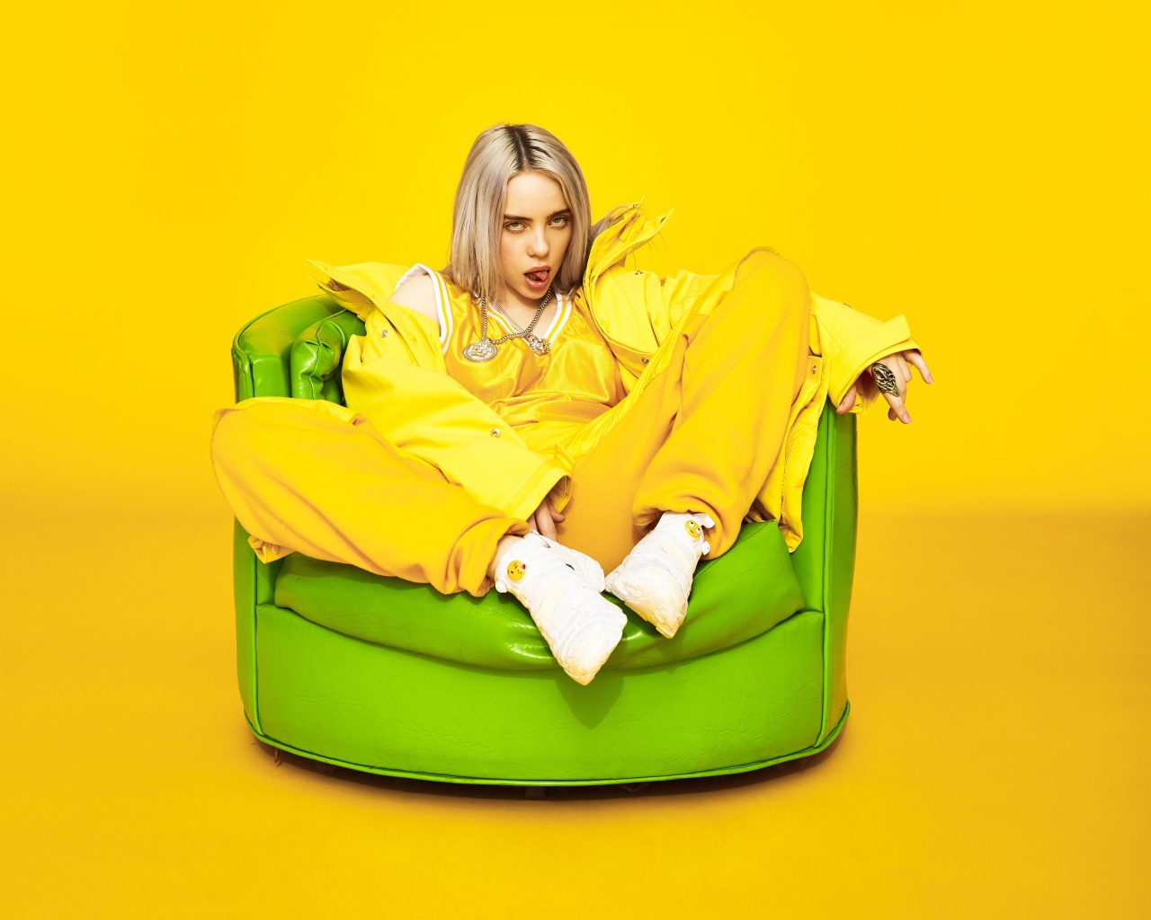 Американская певица Билли Айлиш в кресле на желтом фоне