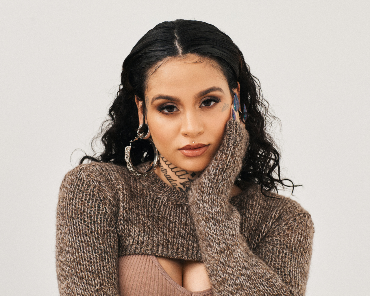 Американская певица Кейлани в свитере на сером фоне