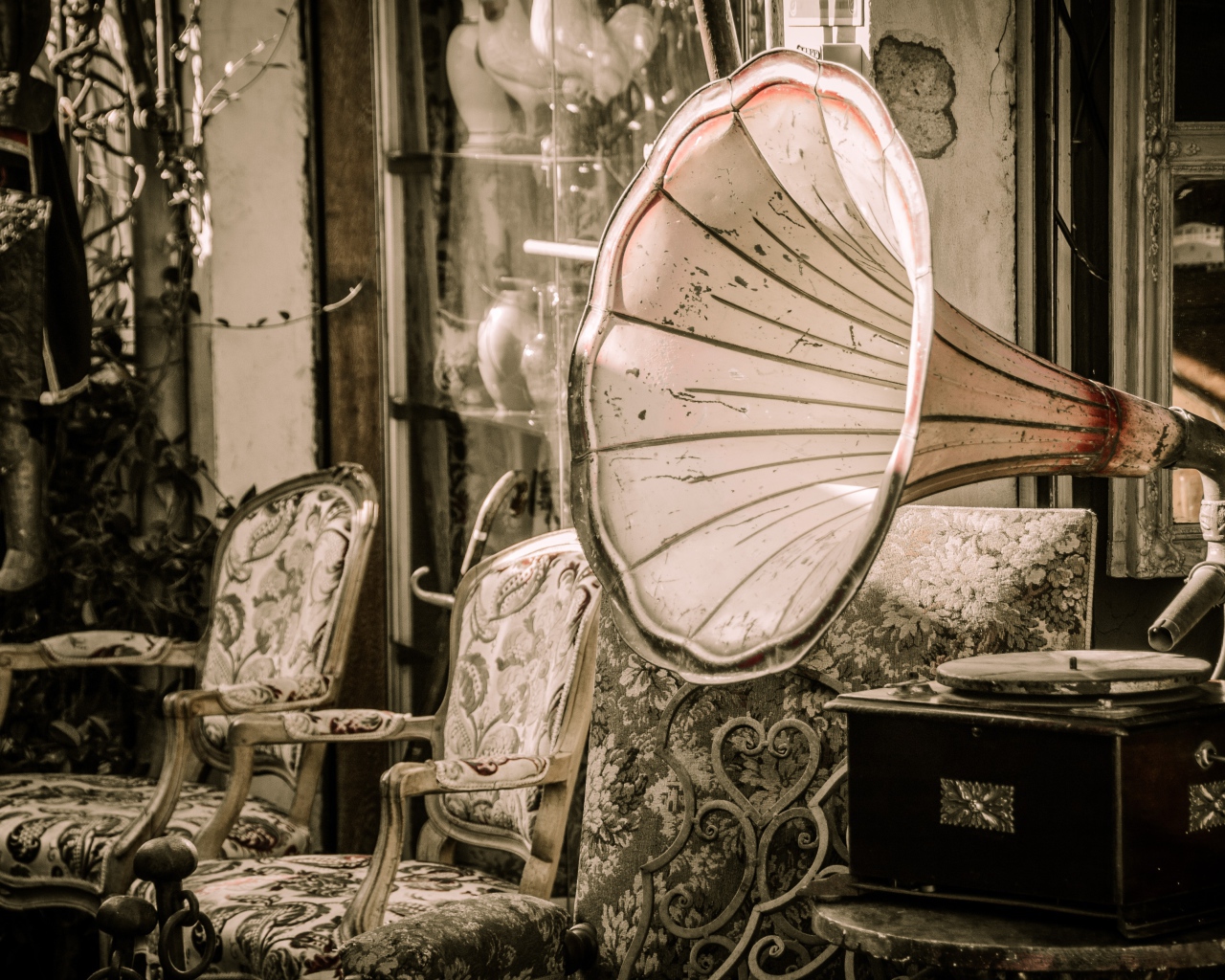 Большой старый граммофон в комнате со стульями