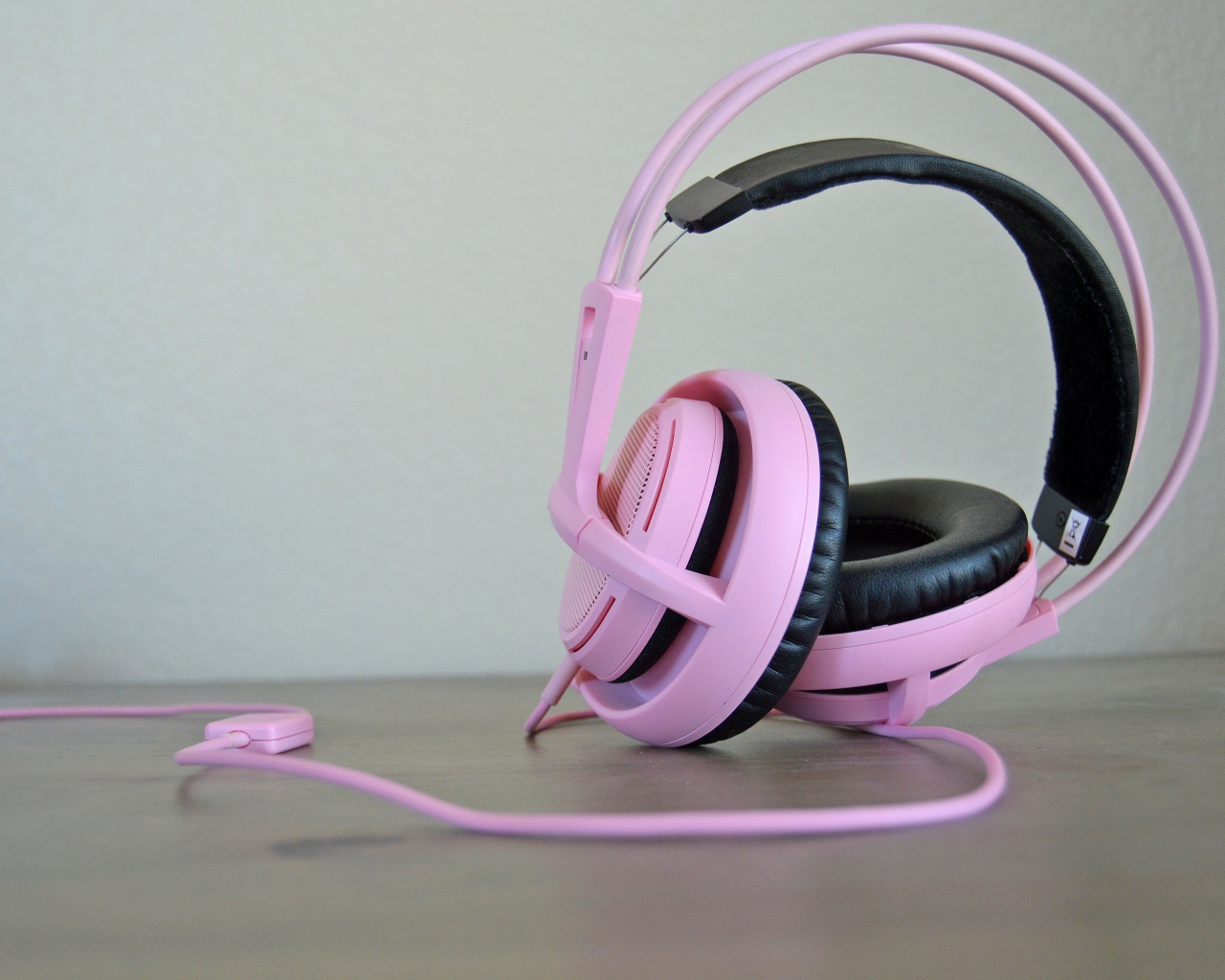 Большие розовые наушники на столе 