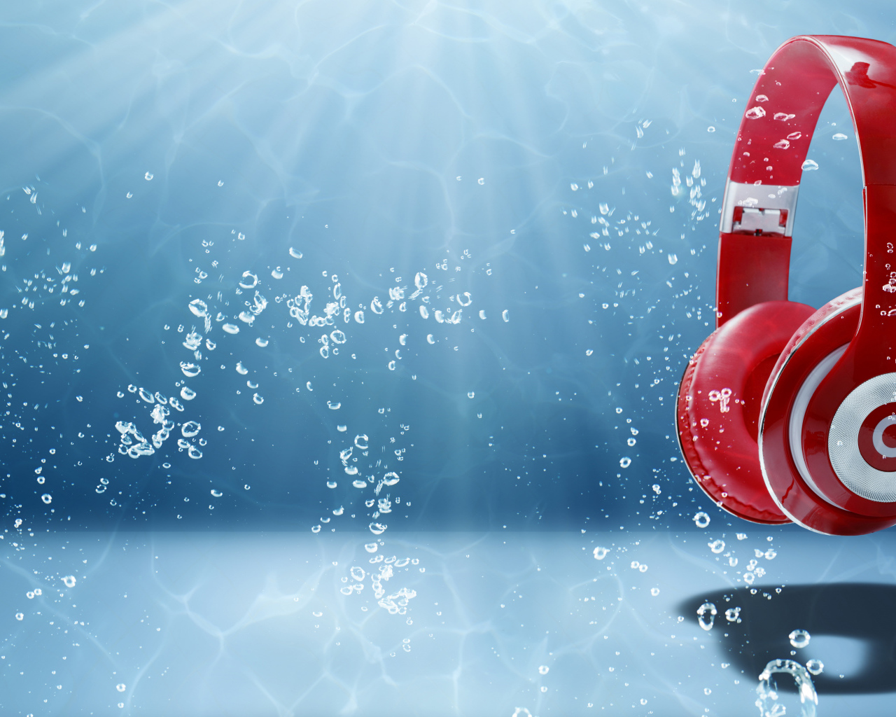 Большие красные наушники под водой на голубом фоне