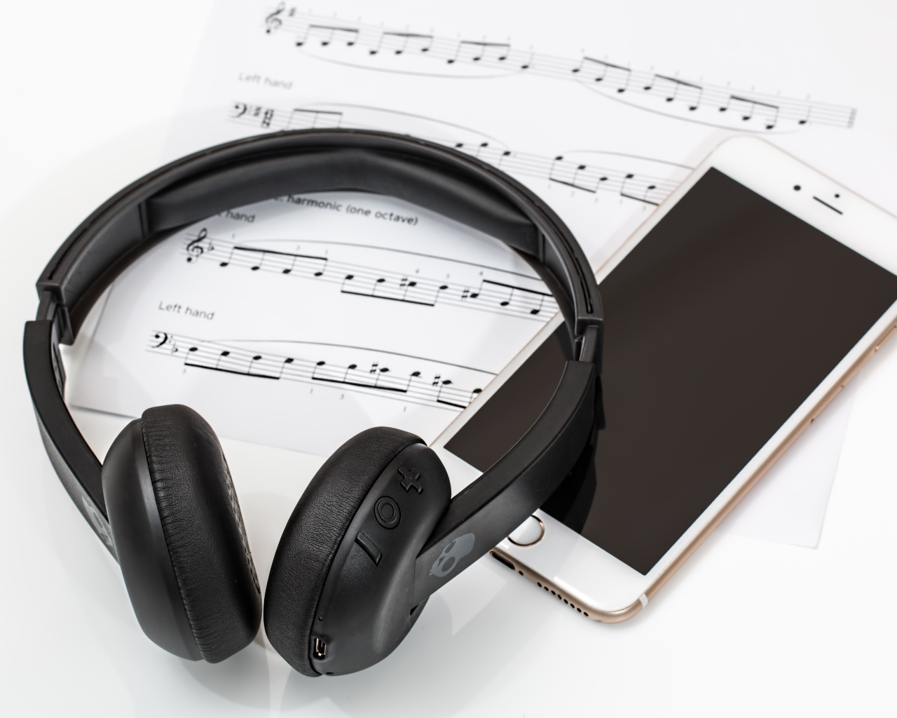 Наушники на столе с нотами и смартфоном
