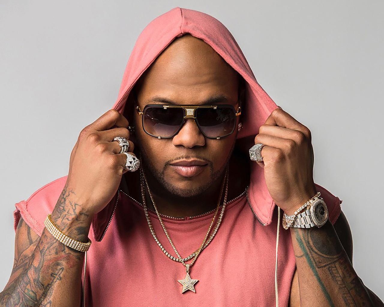 Рэпер Flo Rida на сером фоне