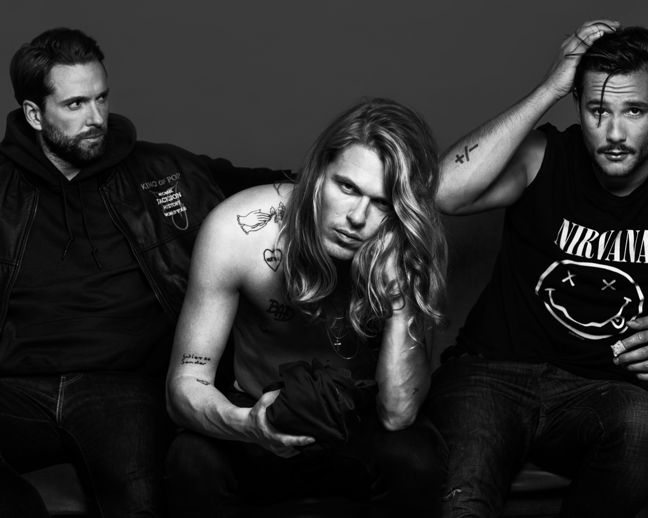 Трио Kris Kross Amsterdam в костюмах на сером фоне