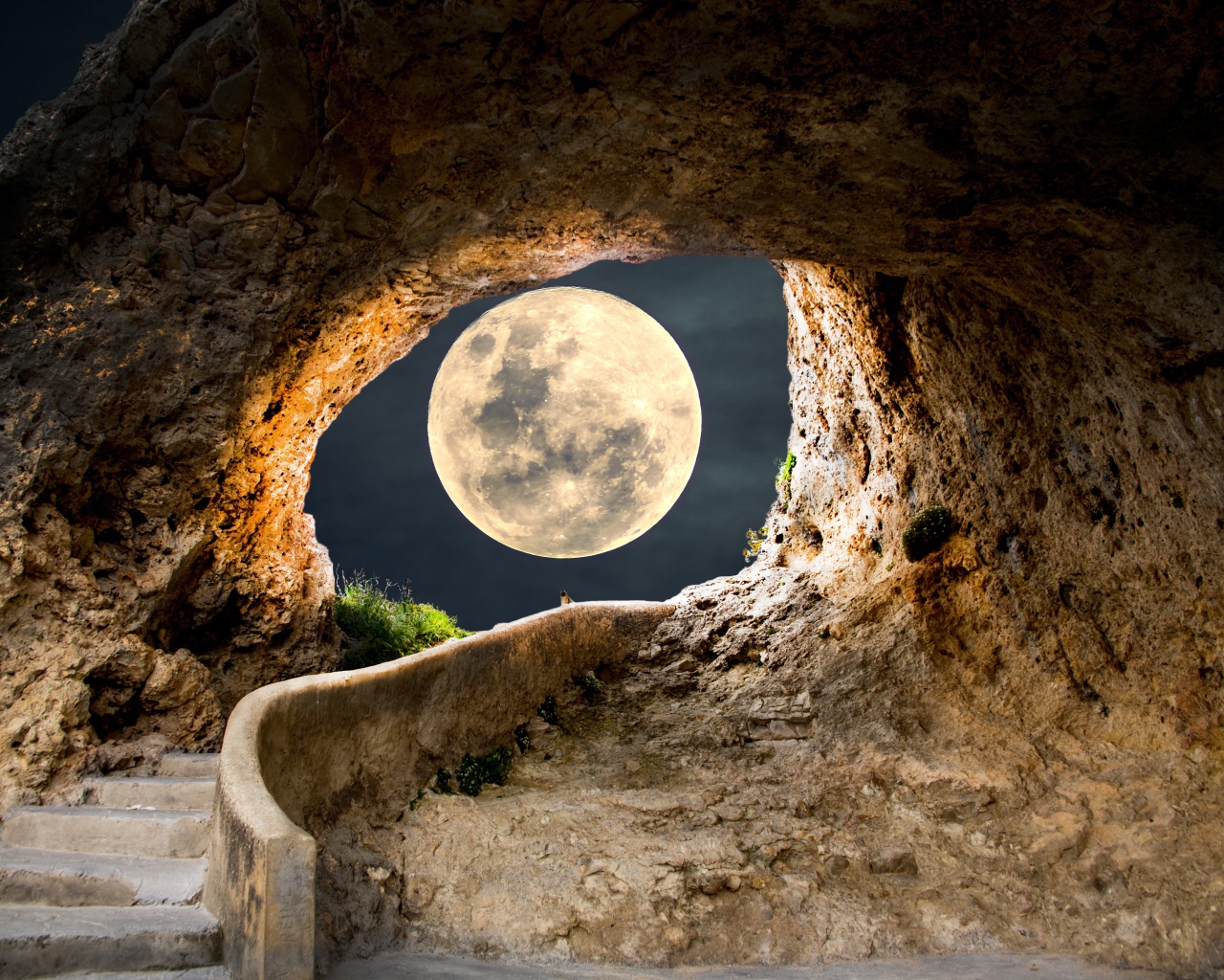 A large white moon illuminates the passage to the cave