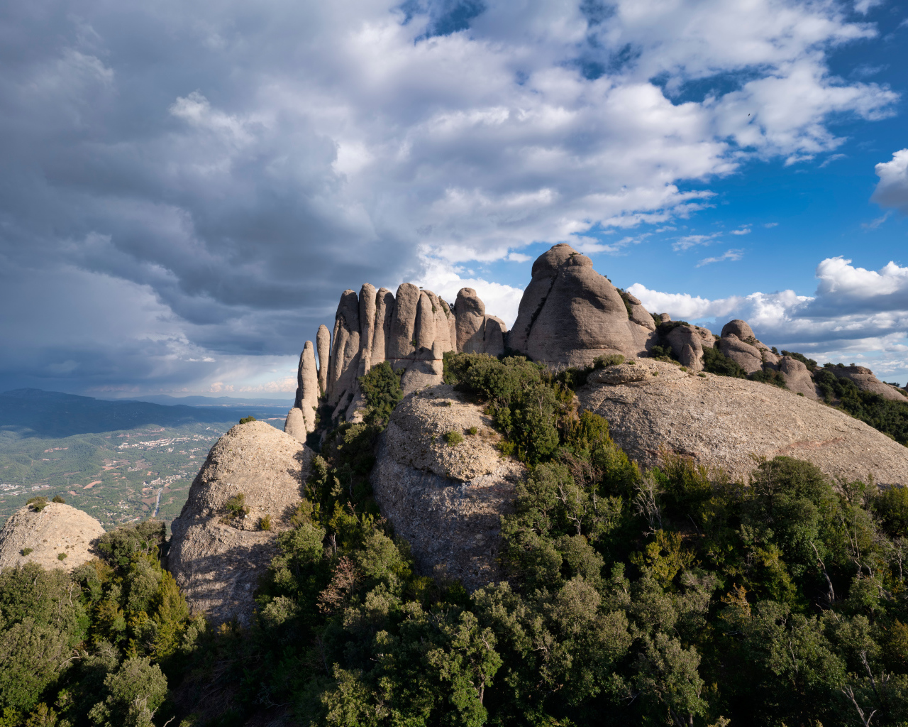 Каменные глыбы под голубым небом с грозовыми облаками 