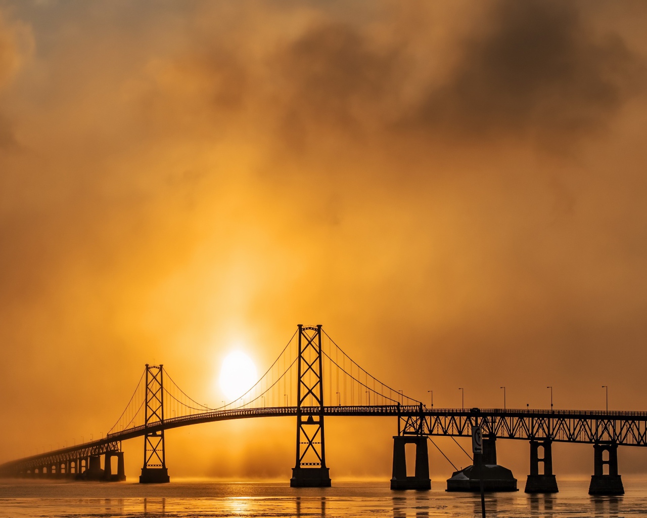 Мост через реку в тумане на восходе солнца