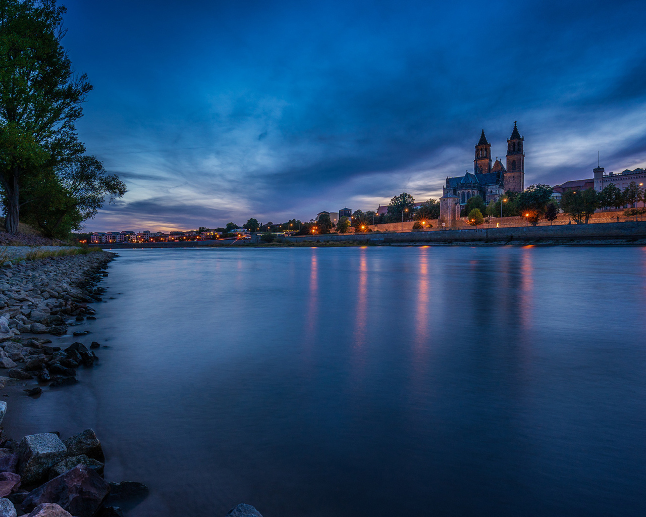 Замок у реки на фоне неба в сумерках 