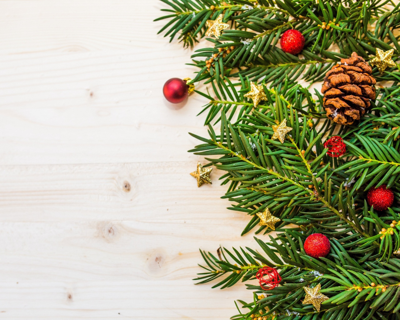 Зеленые ветки ели, шишки и игрушки на белом фоне