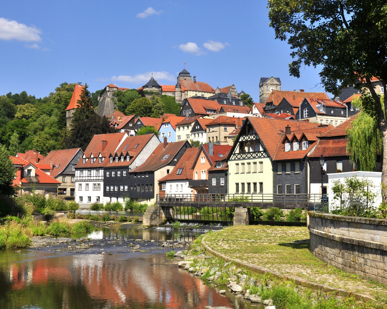 Много домов у пруда на фоне голубого неба