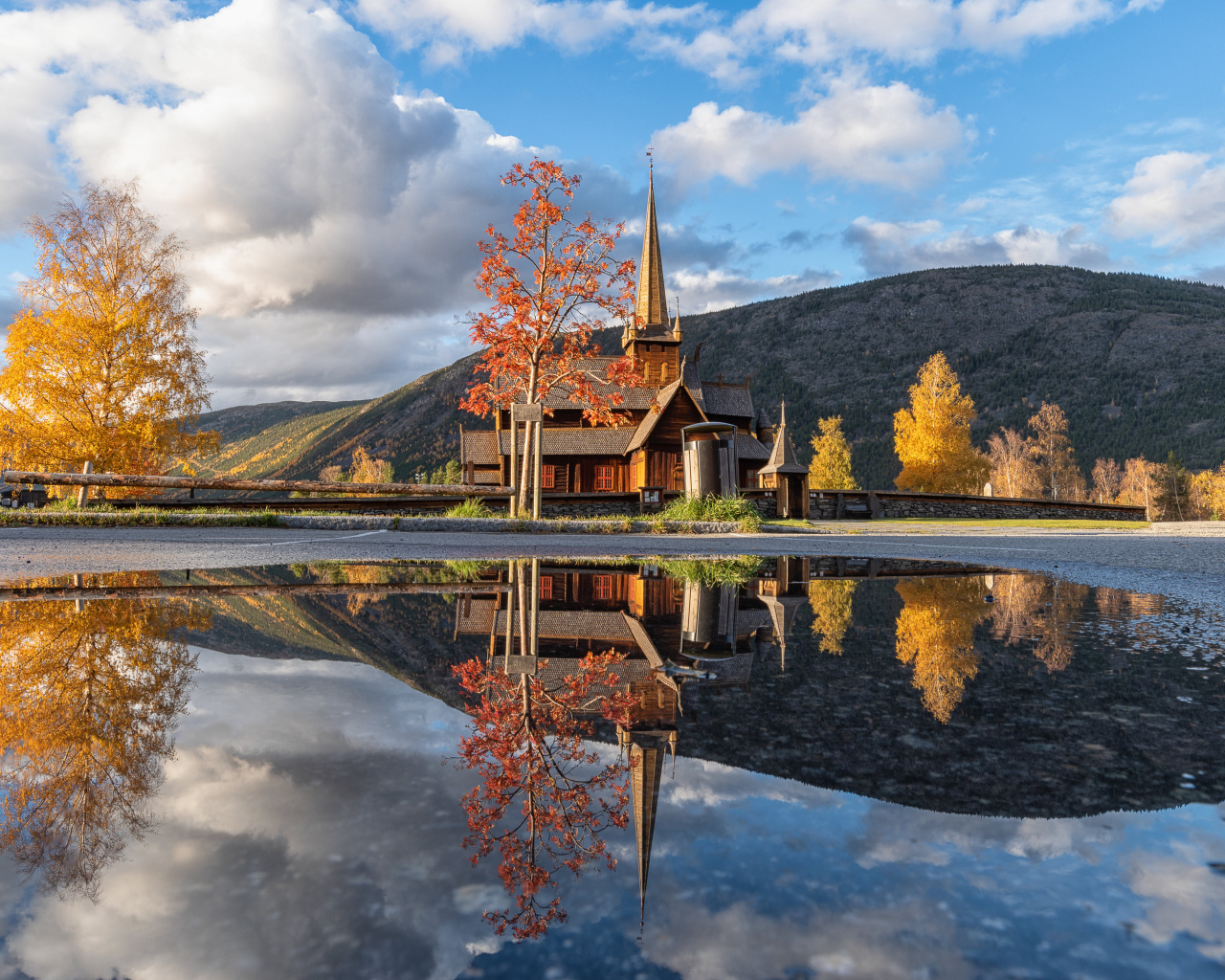 Старый храм отражается в воде под голубым небом 