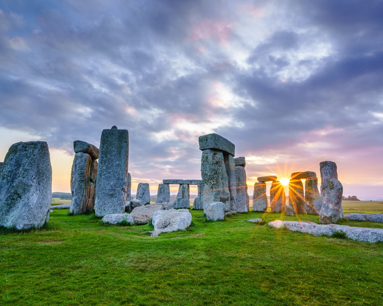 The sun breaks through the stones of Stonehenge