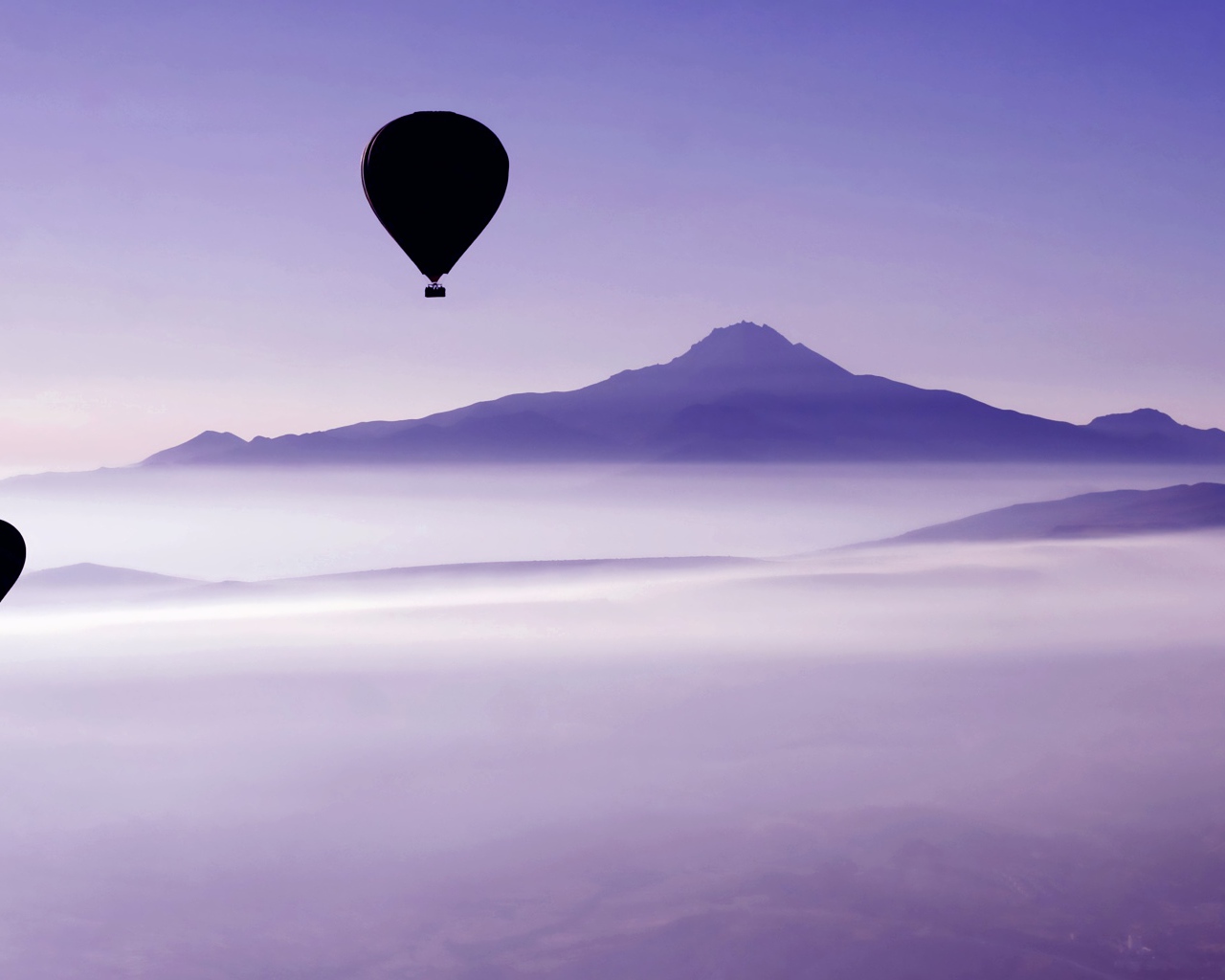 Два воздушных шара в небе над облаками