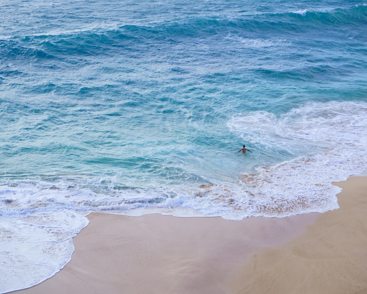 Голубая вода океана на пляже с желтым песком