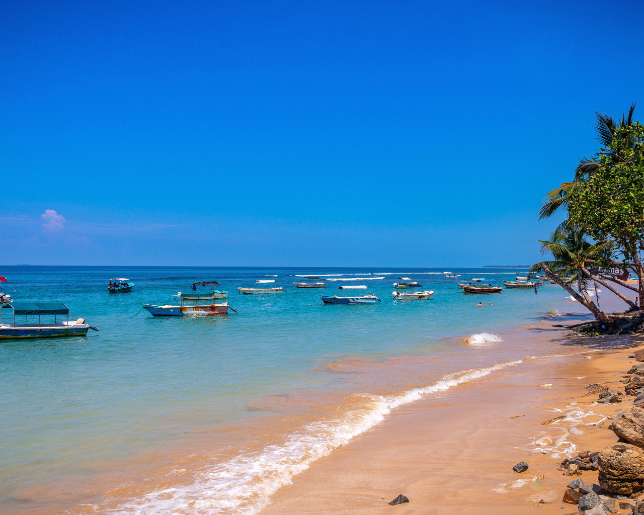 Лодки на берегу тропического пляжа на фоне голубого неба 