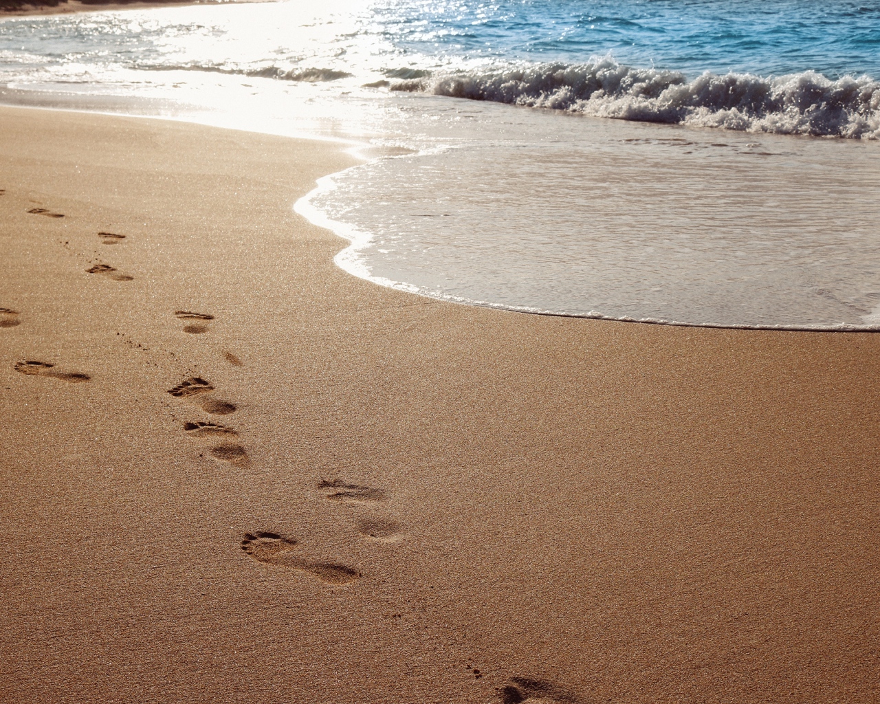 Следы ног на мокром морском песке 