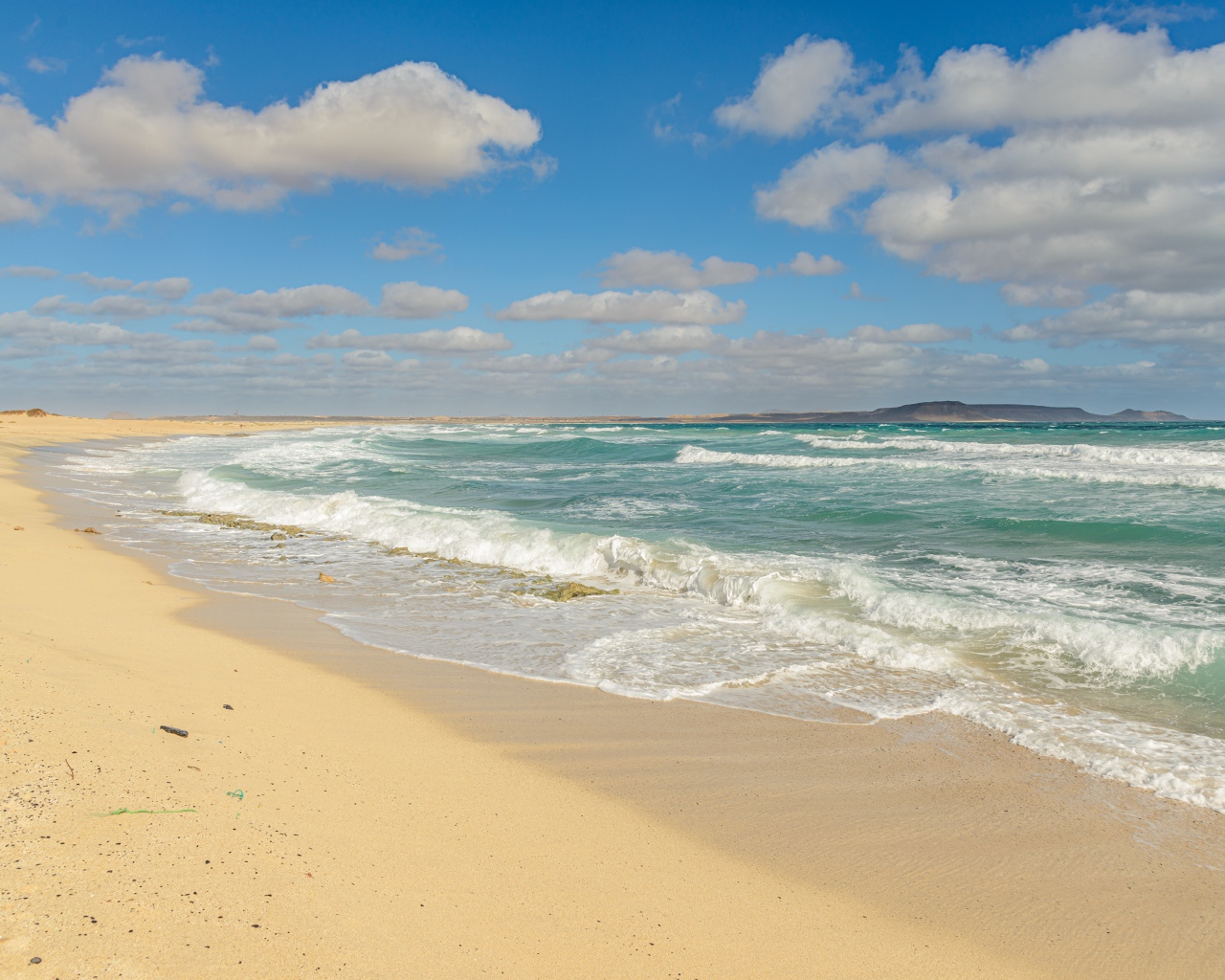 Бушующие морские волны на желтом горячем песке 