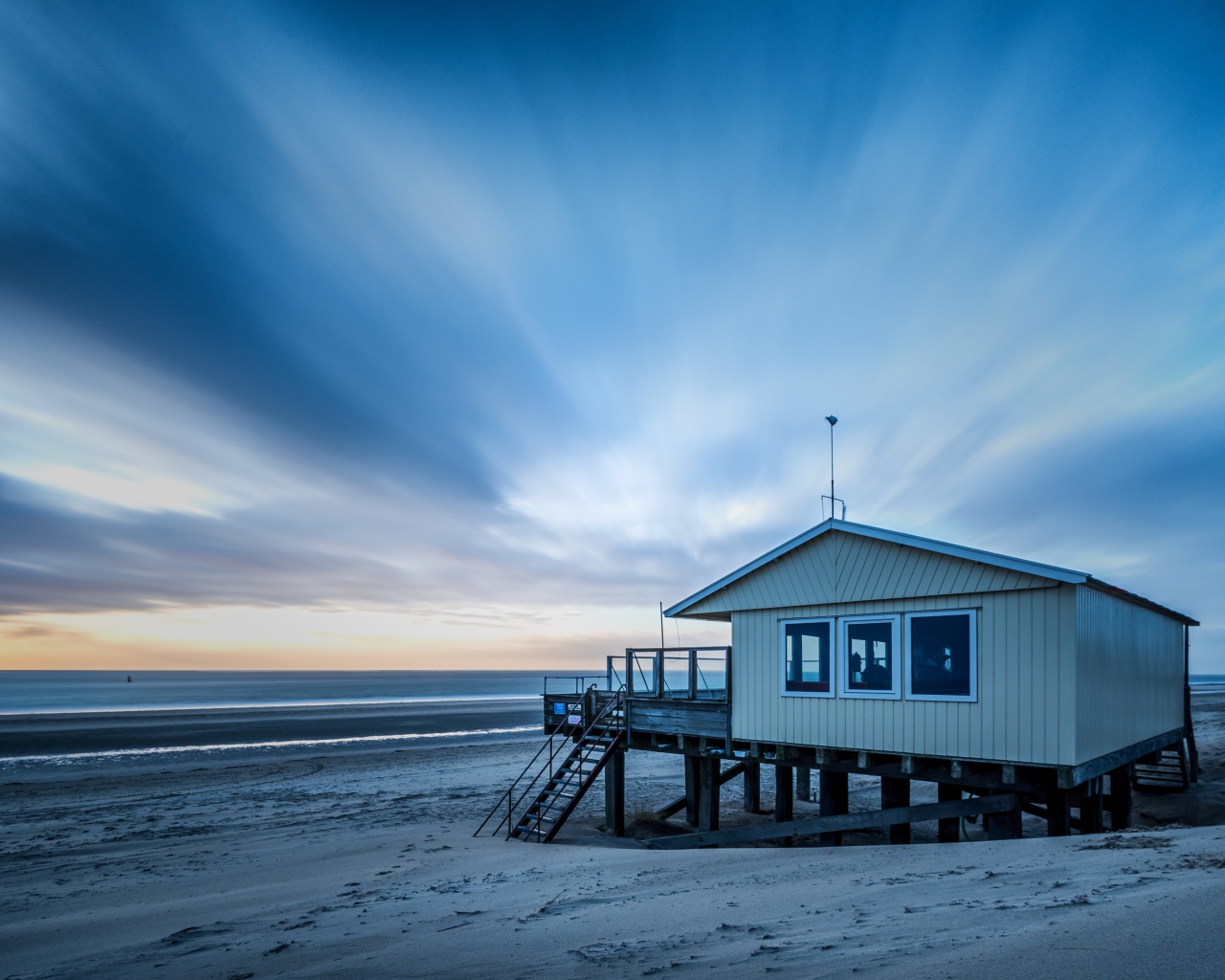 Дом спасателей стоит на пляже под красивым небом