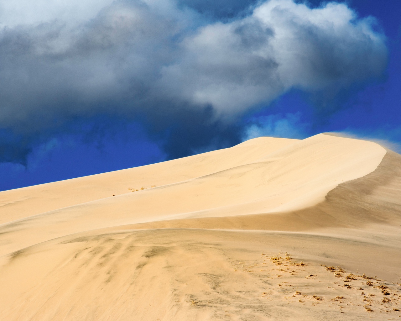 Песчаный бархан под голубым небом