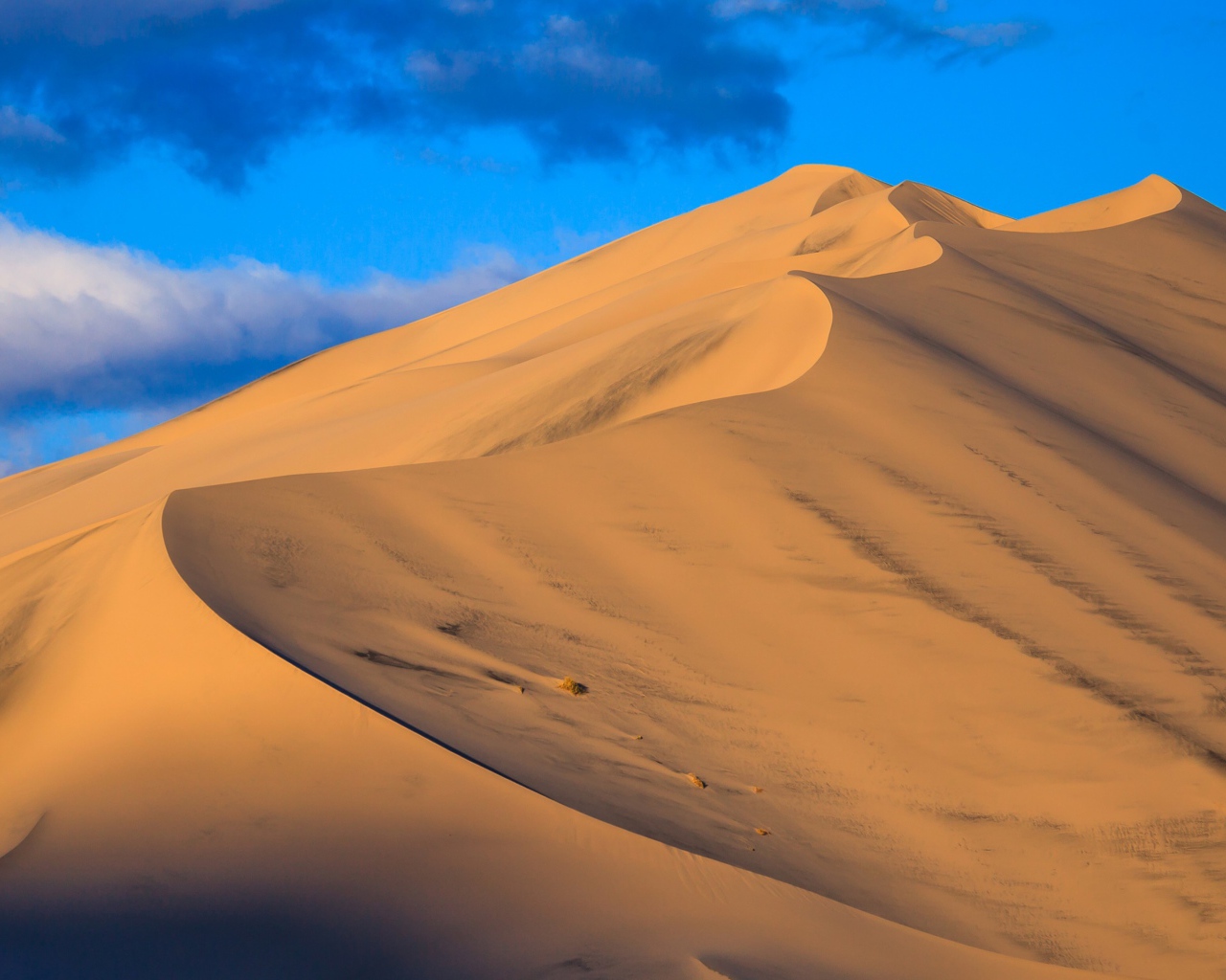 Песчаные дюны под голубым небом 