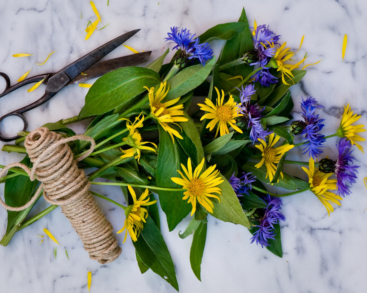 Букет васильков с желтыми цветами на столе с веревкой и ножницами