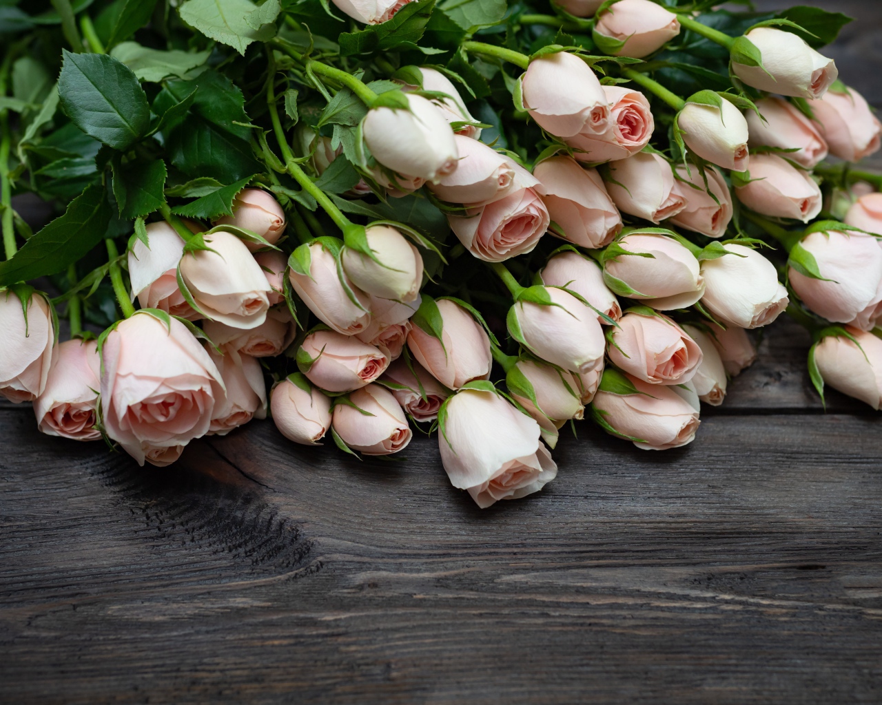 Большой букет розовых роз на деревянном столе 
