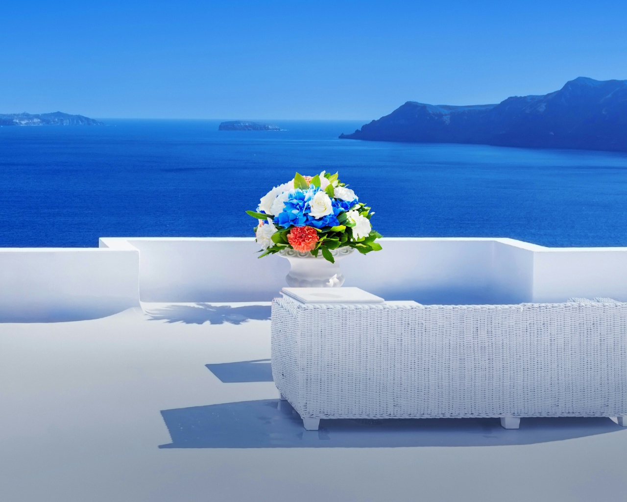 Красивый букет цветов на белом столе на фоне моря