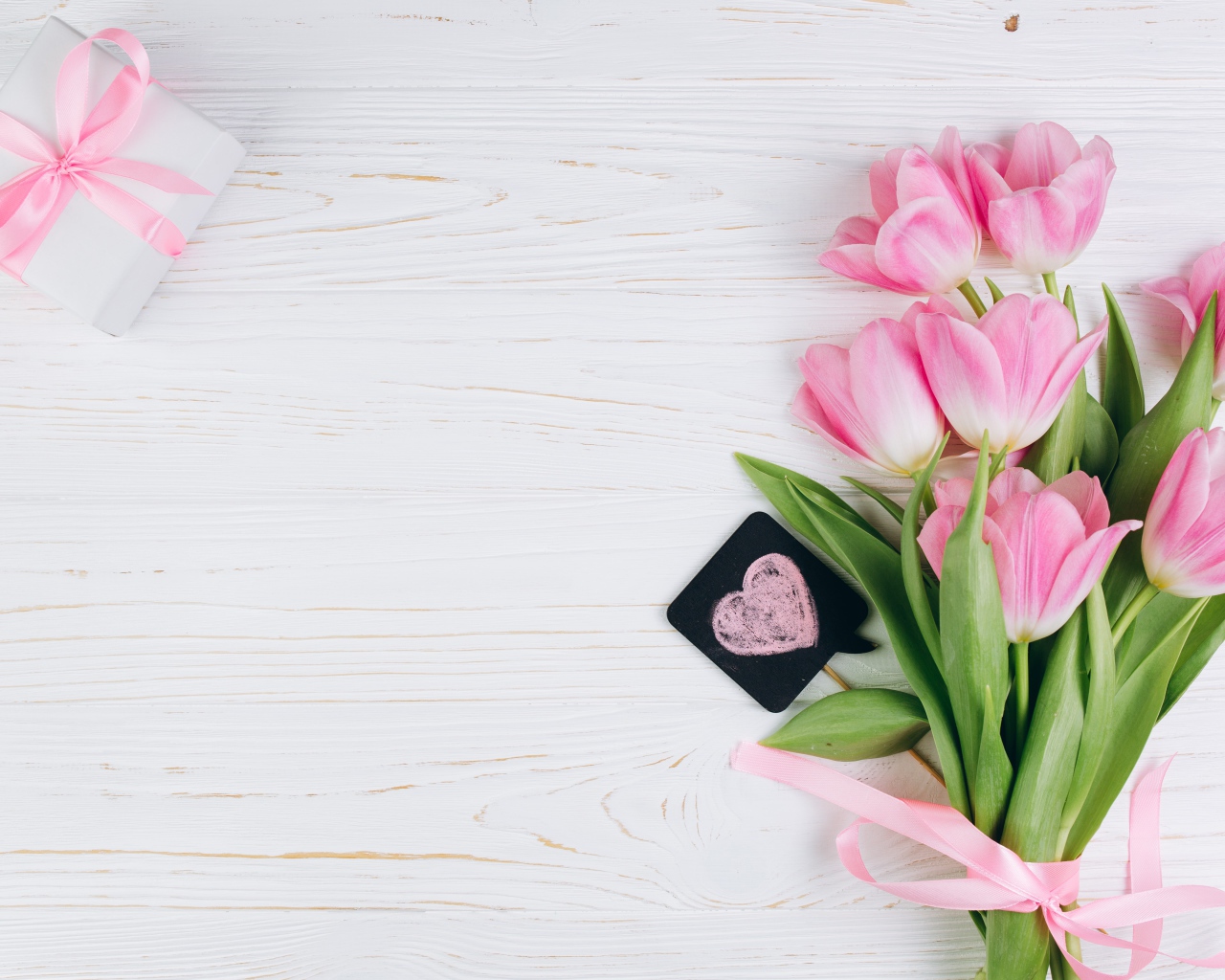 Красивый букет розовых тюльпанов с подарком на сером фоне