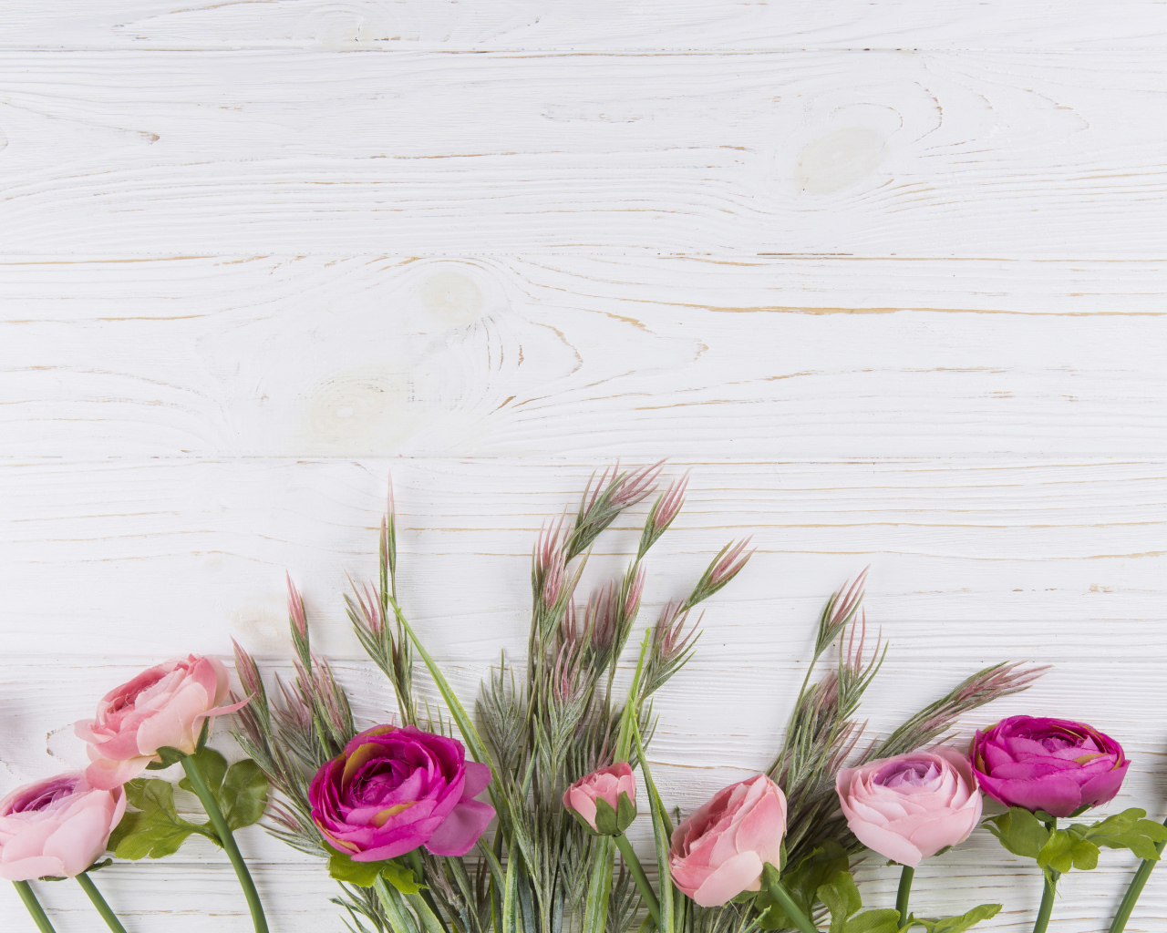 Букет разноцветных лютиков на белом столе