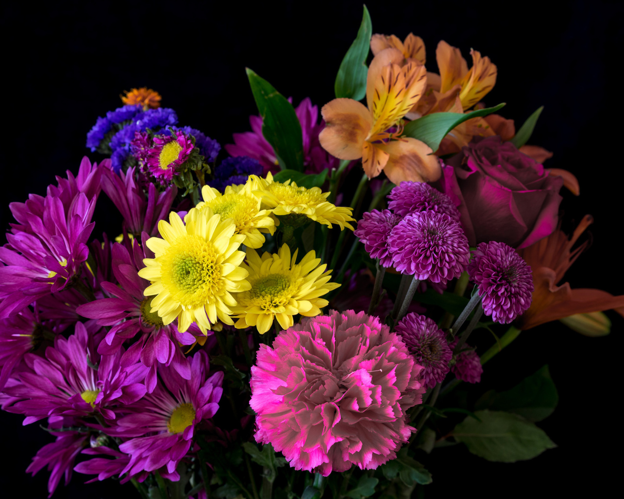 Букет разноцветных цветов на черном фоне крупным планом
