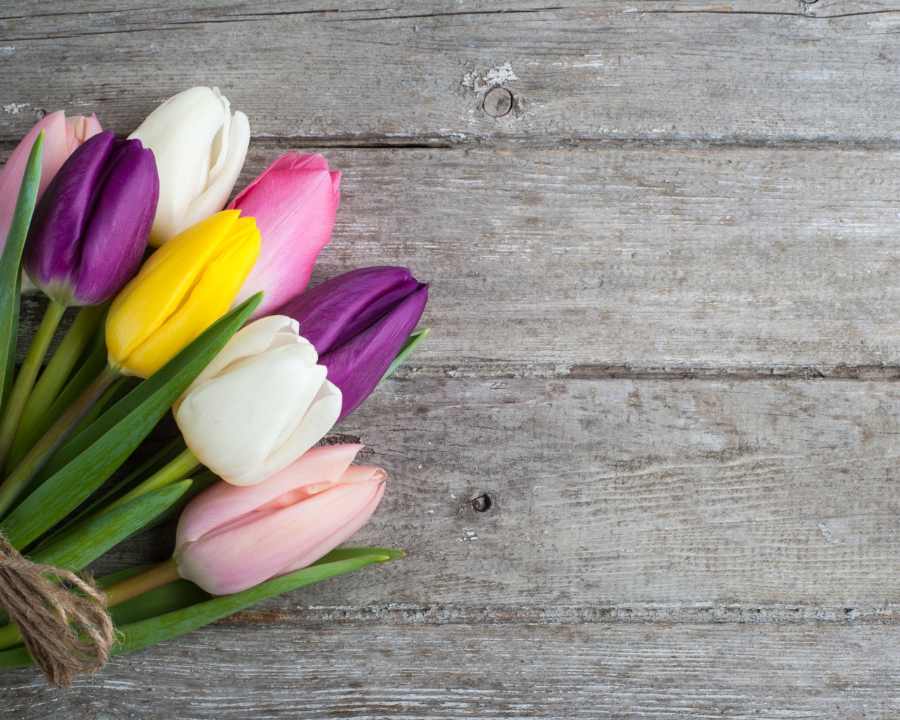 Букет разноцветных тюльпанов на деревянном столе