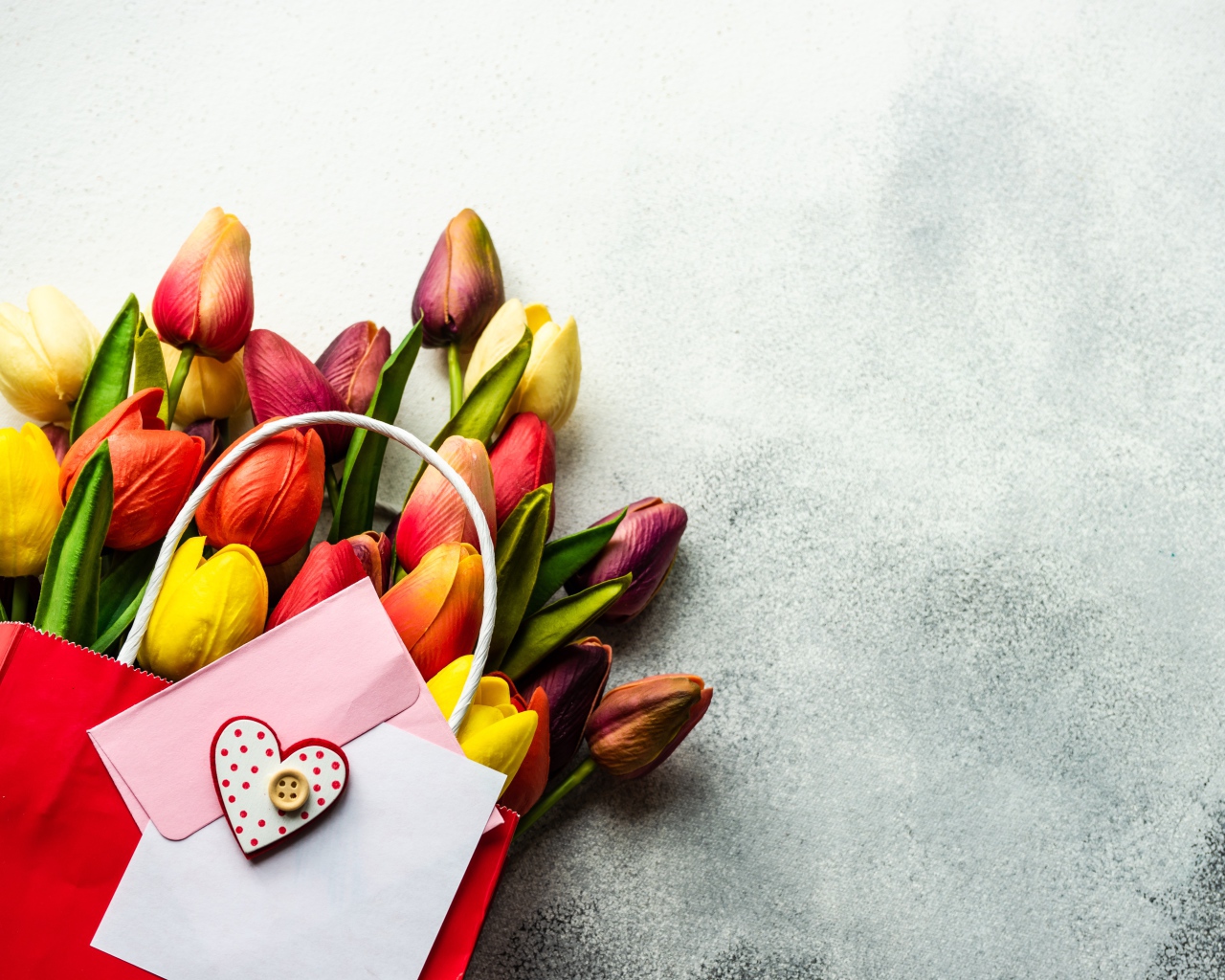 Букет разноцветных тюльпанов с письмом на сером фоне