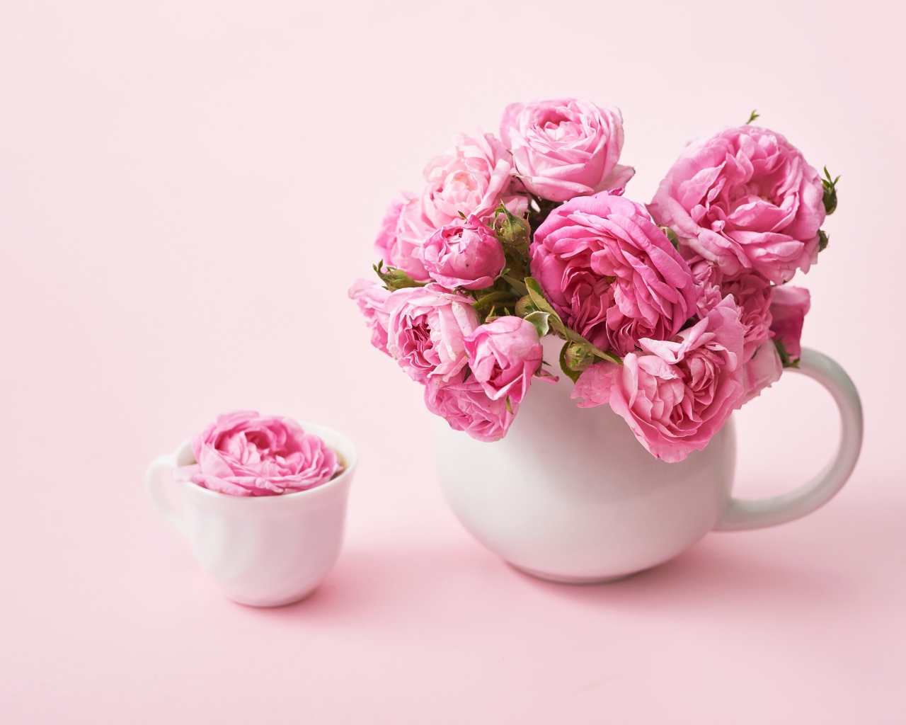 Букет розовых роз в белом кувшине на столе