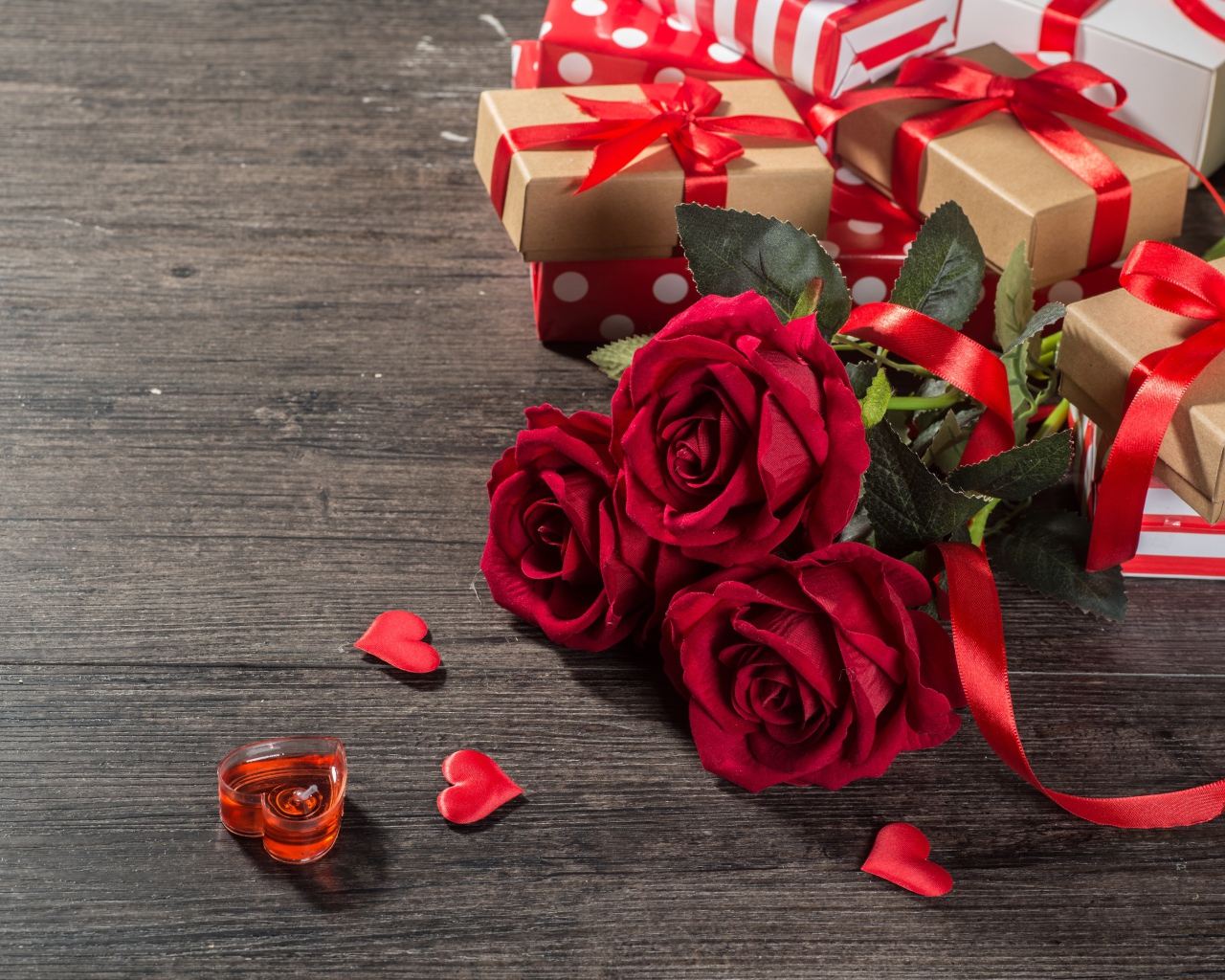 Букет красных роз и подарки на столе 