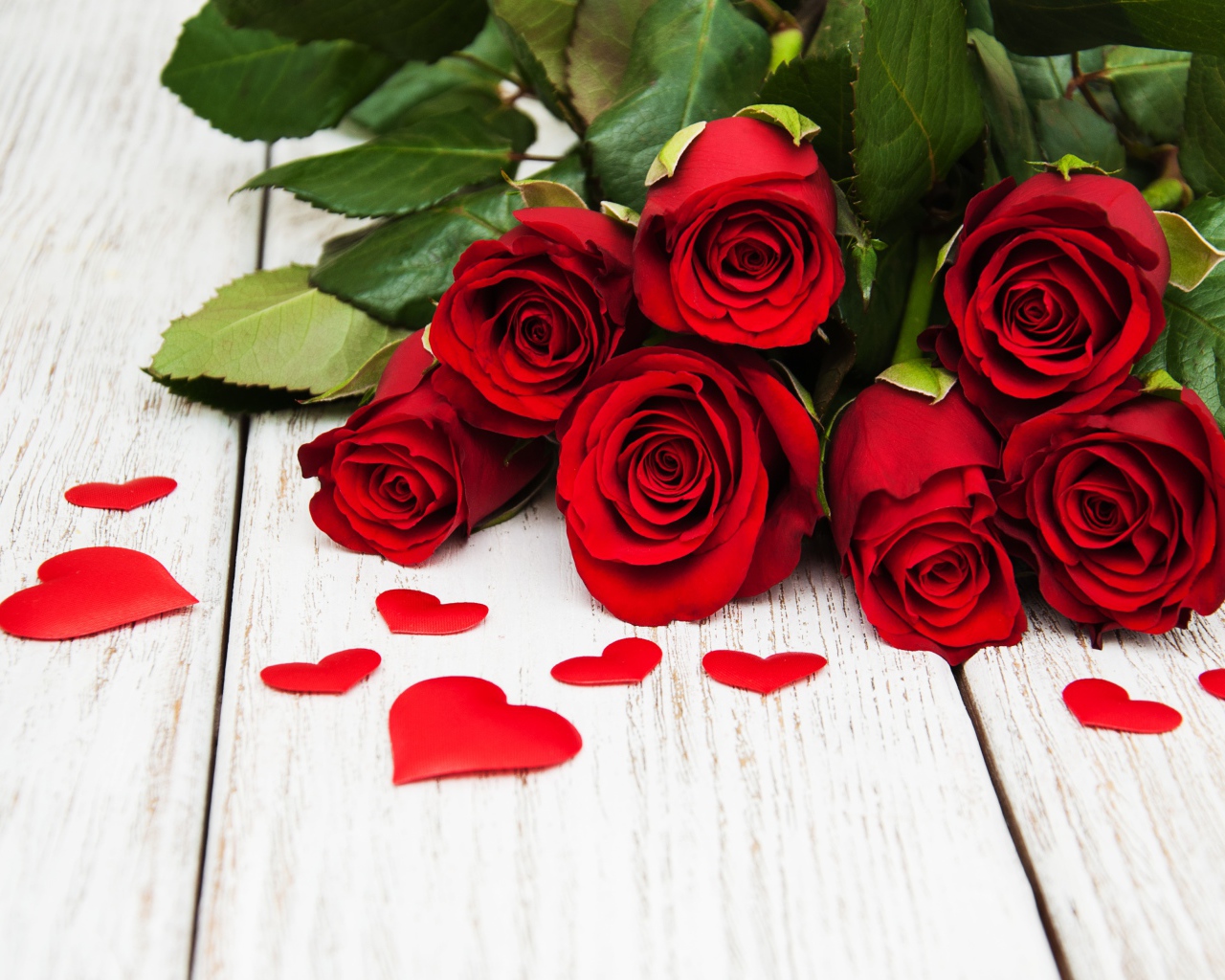 Букет красных роз с зелеными листьями на белом фоне с сердечками 