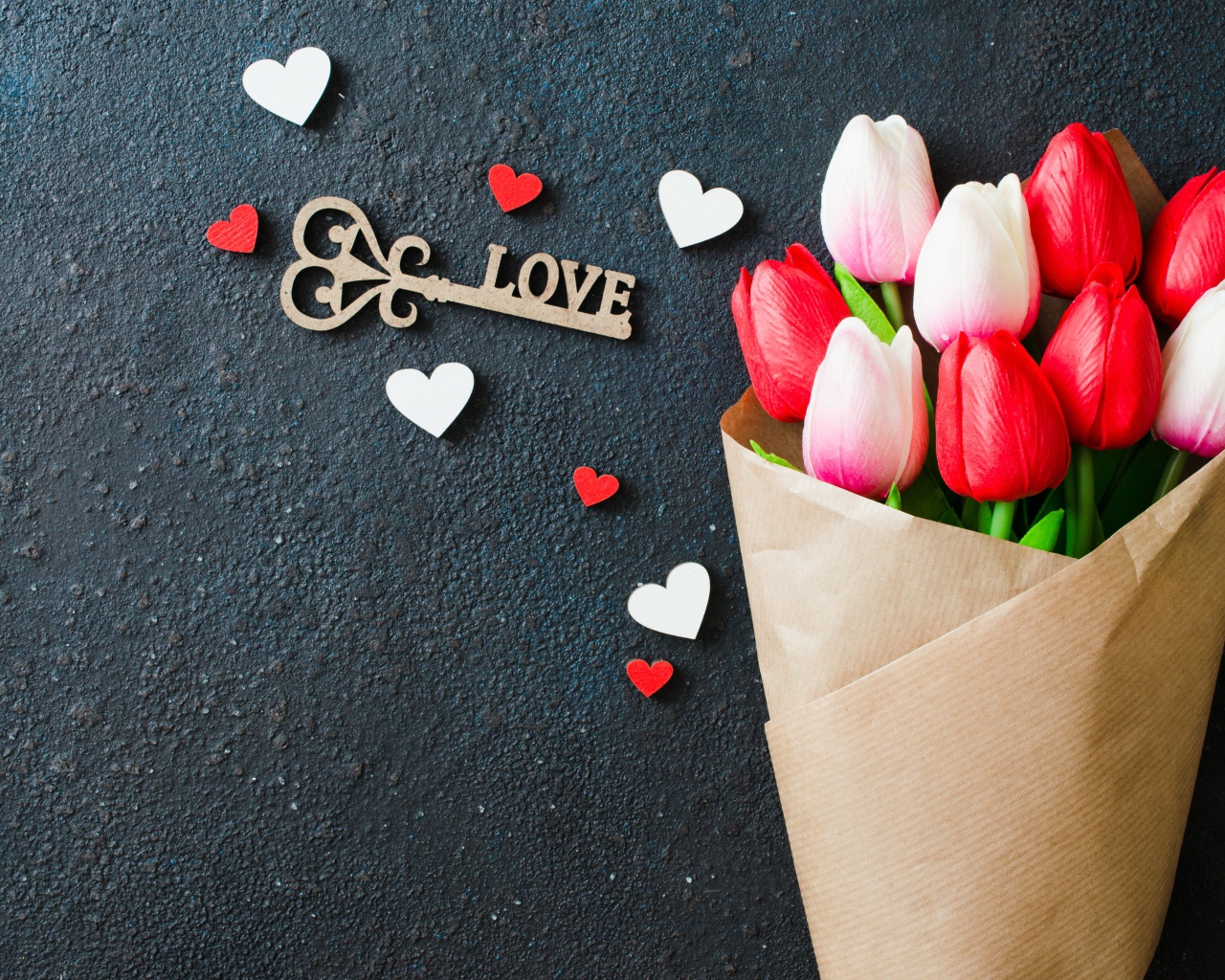 Букет тюльпанов в бумаге на черном фоне с ключом