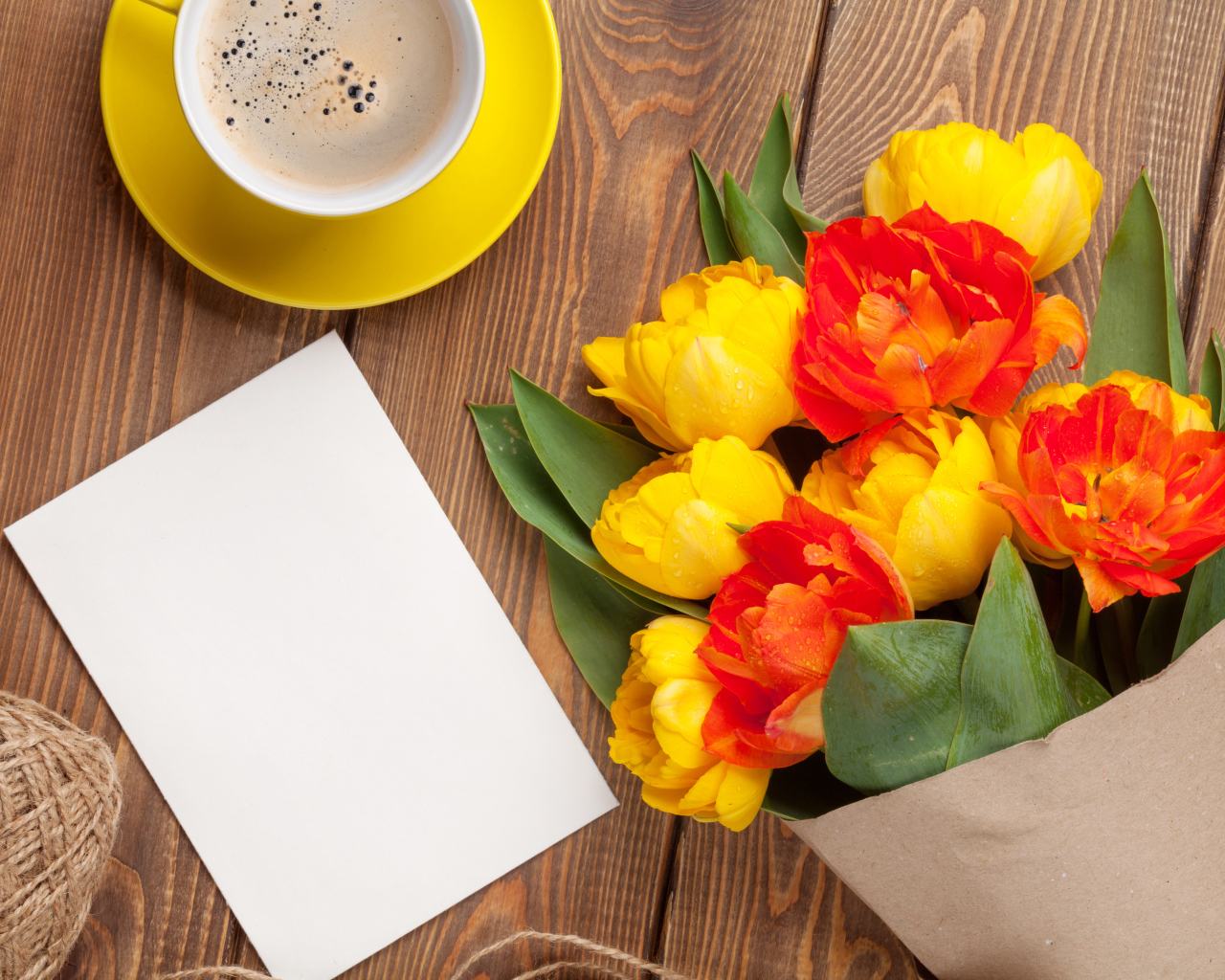 Букет тюльпанов на столе с листом бумаги и чашкой кофе