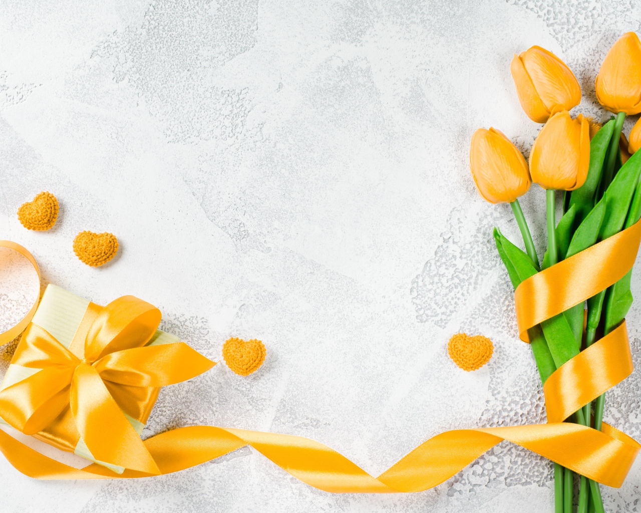 Букет желтых тюльпанов с лентой и подарком на сером фоне