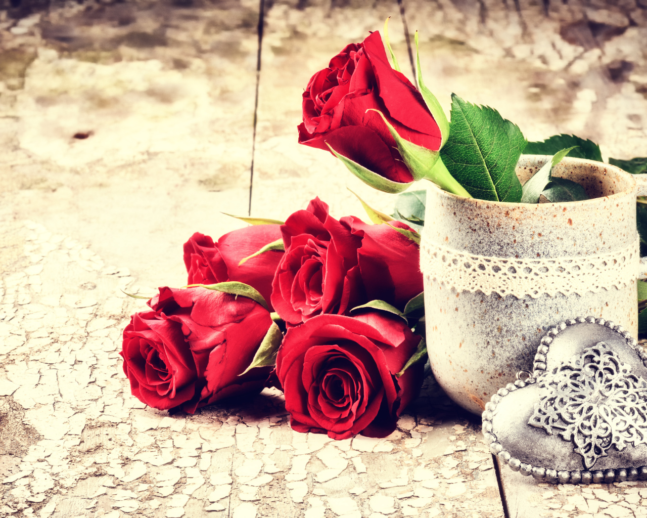 Красные розы на столе с кружкой и сердцем 