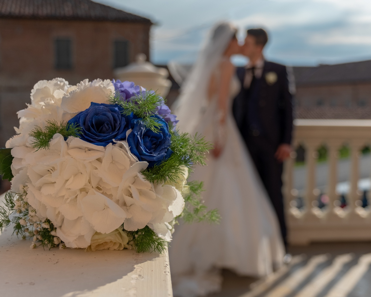 Свадебный букет на фоне новобрачной пары 