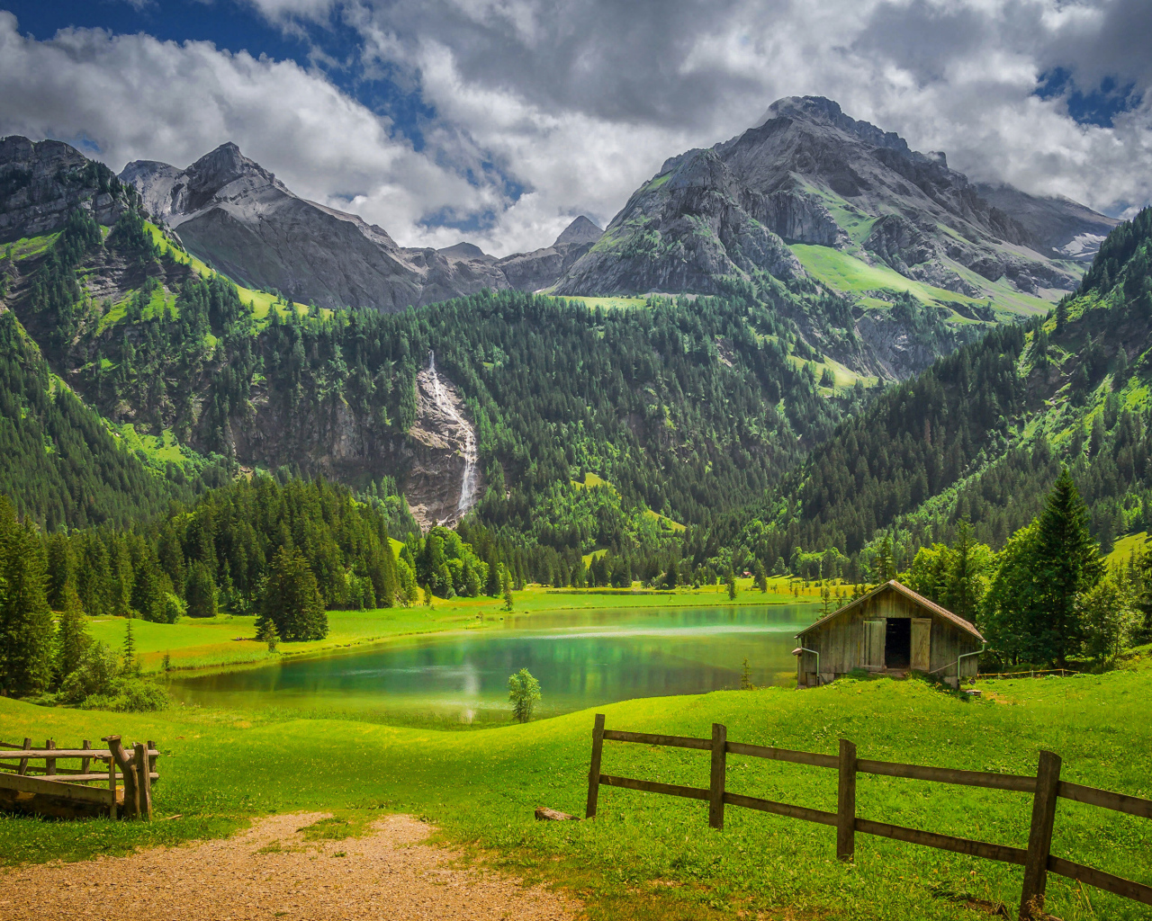 Красивые покрытые зелеными деревьями горы у озера