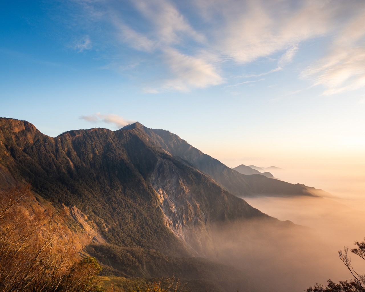 Красивый вид на покрытые туманом горы под голубым небом