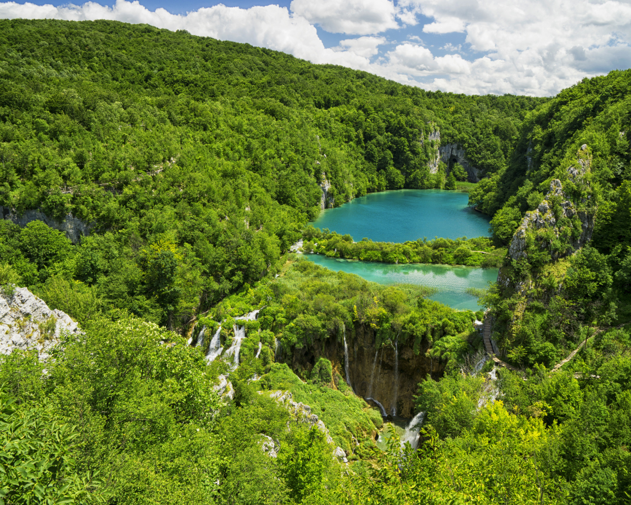 Голубая вода в озере у покрытых деревьями гор 