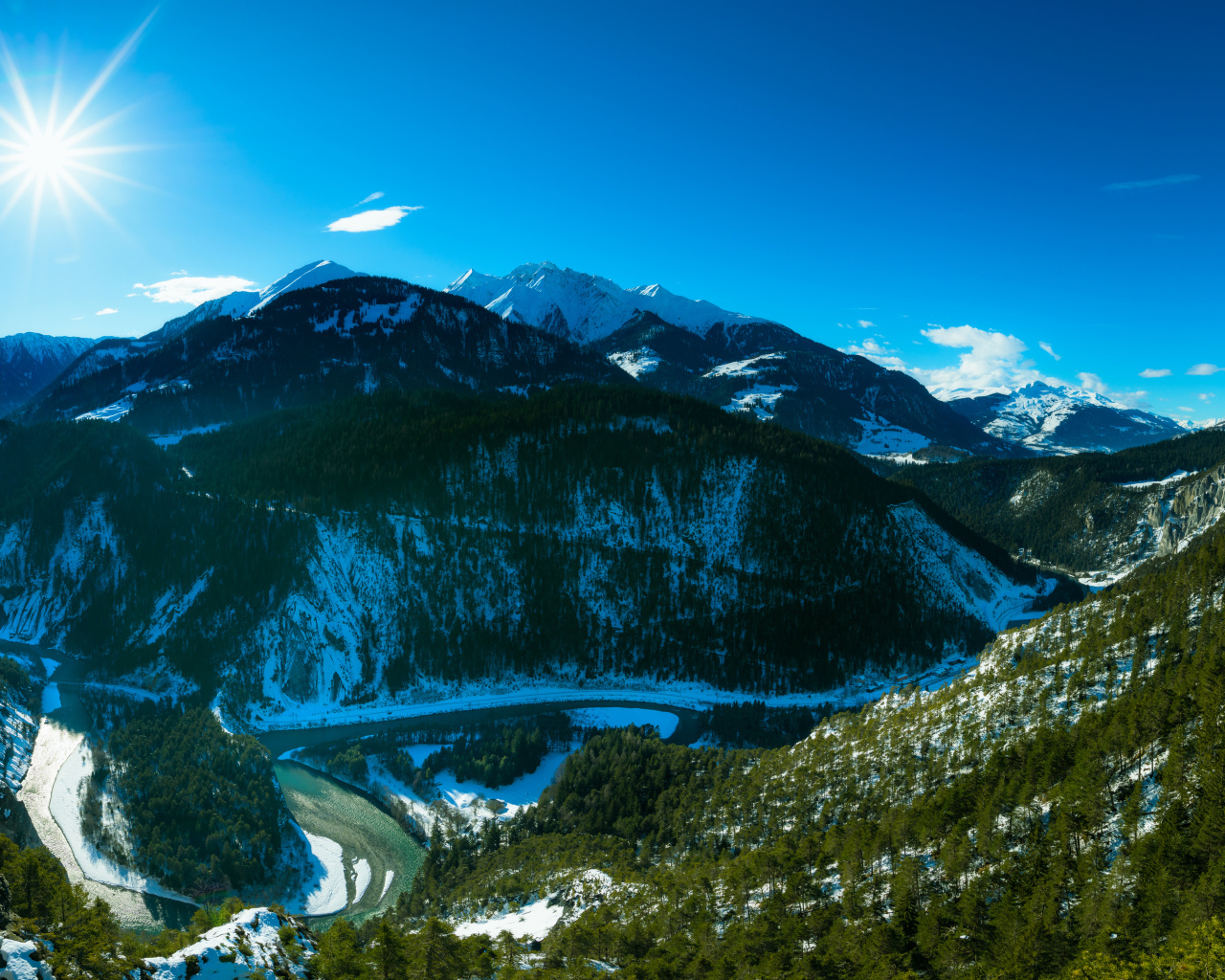 Яркое солнце в голубом небе над заснеженными горами, Швейцария 