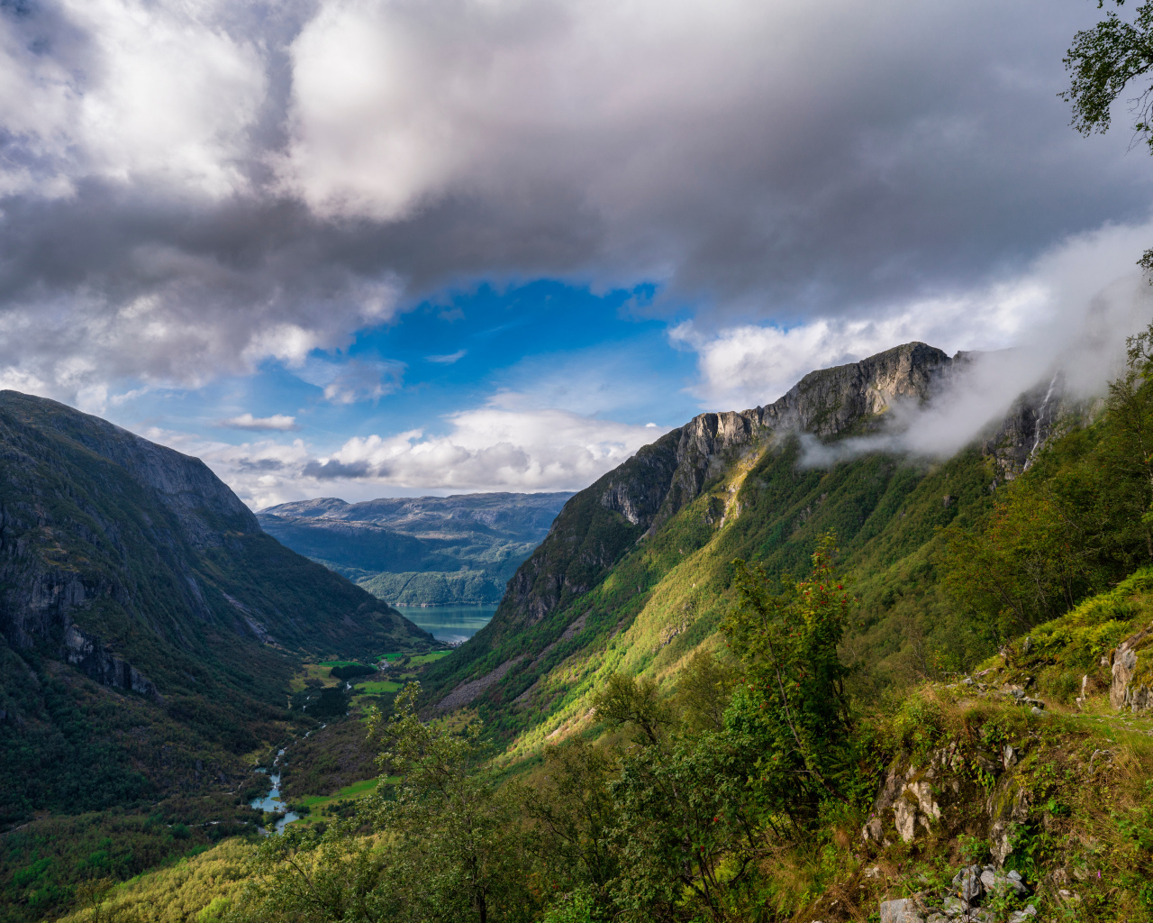 Покрытые зеленой растительностью горы под белыми облаками, Норвегия