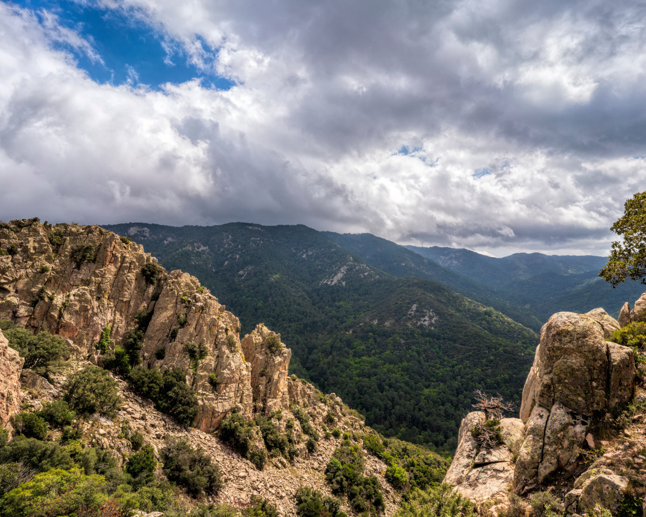 Зеленые вершины гор под белыми облаками 