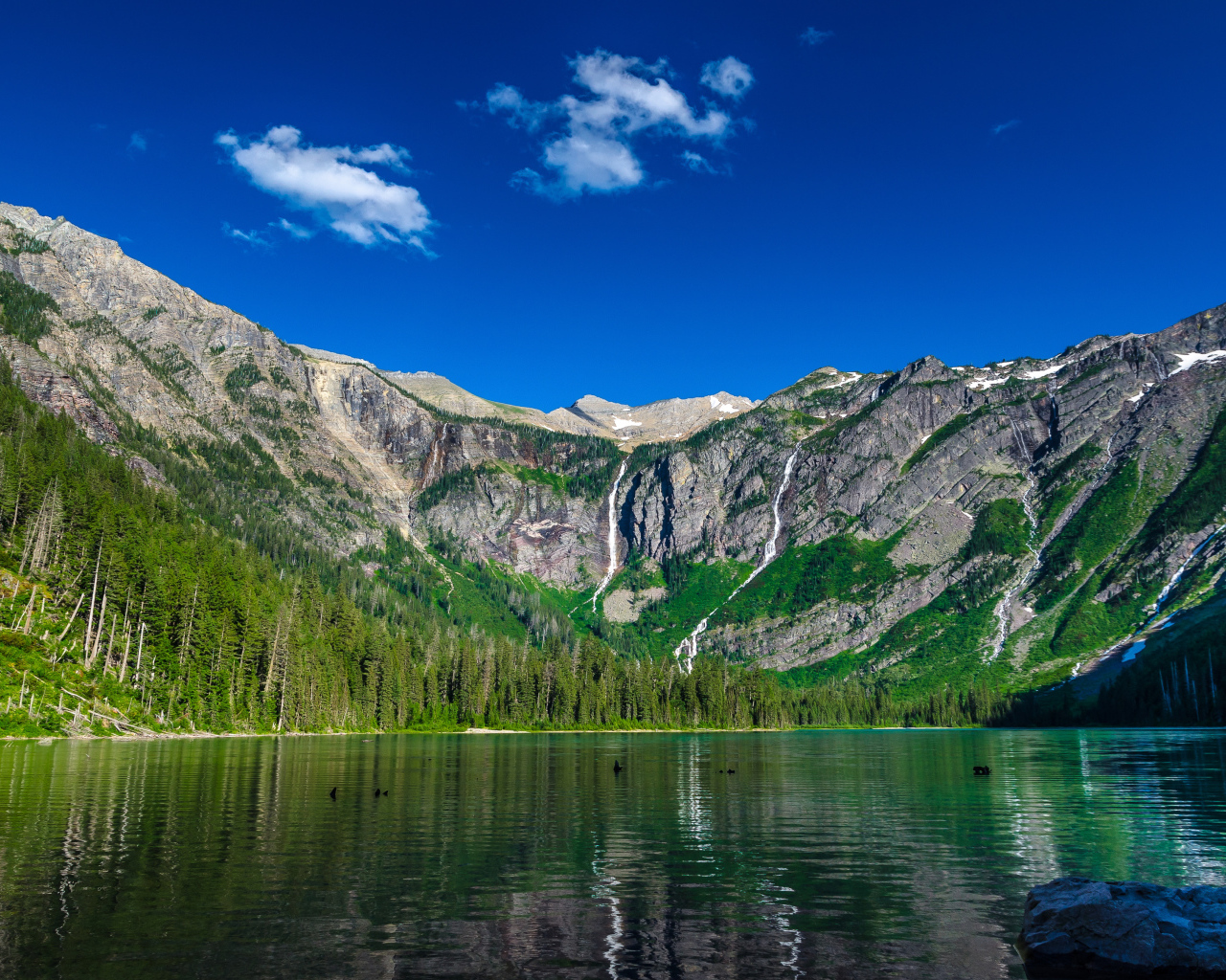 Горы под голубым небом у озера