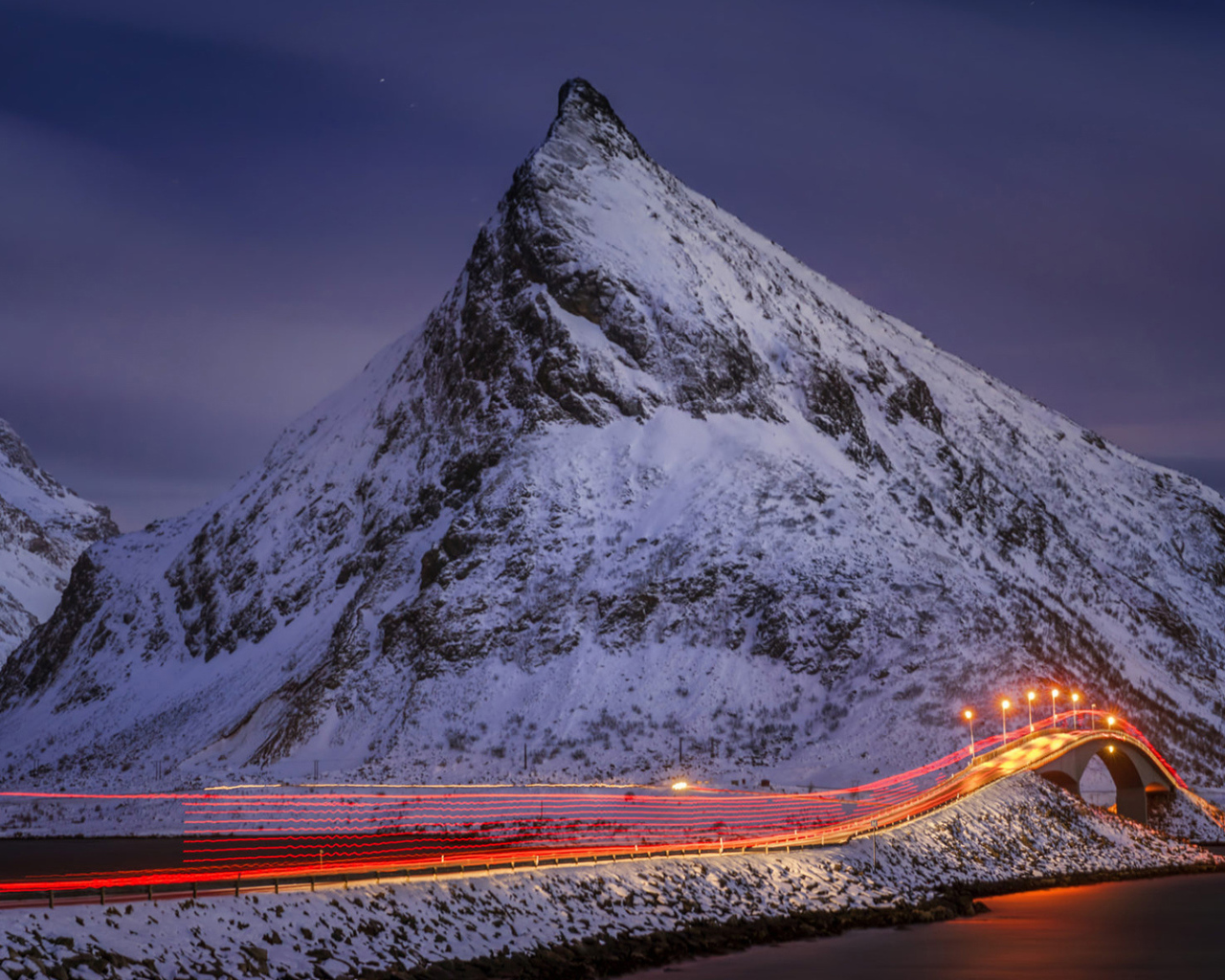 Ночная дорога у заснеженных гор 