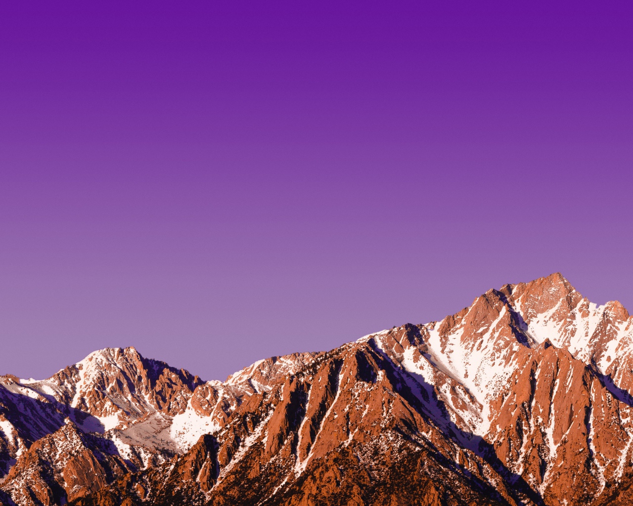 Вершины заснеженных гор на фоне сиреневого заката