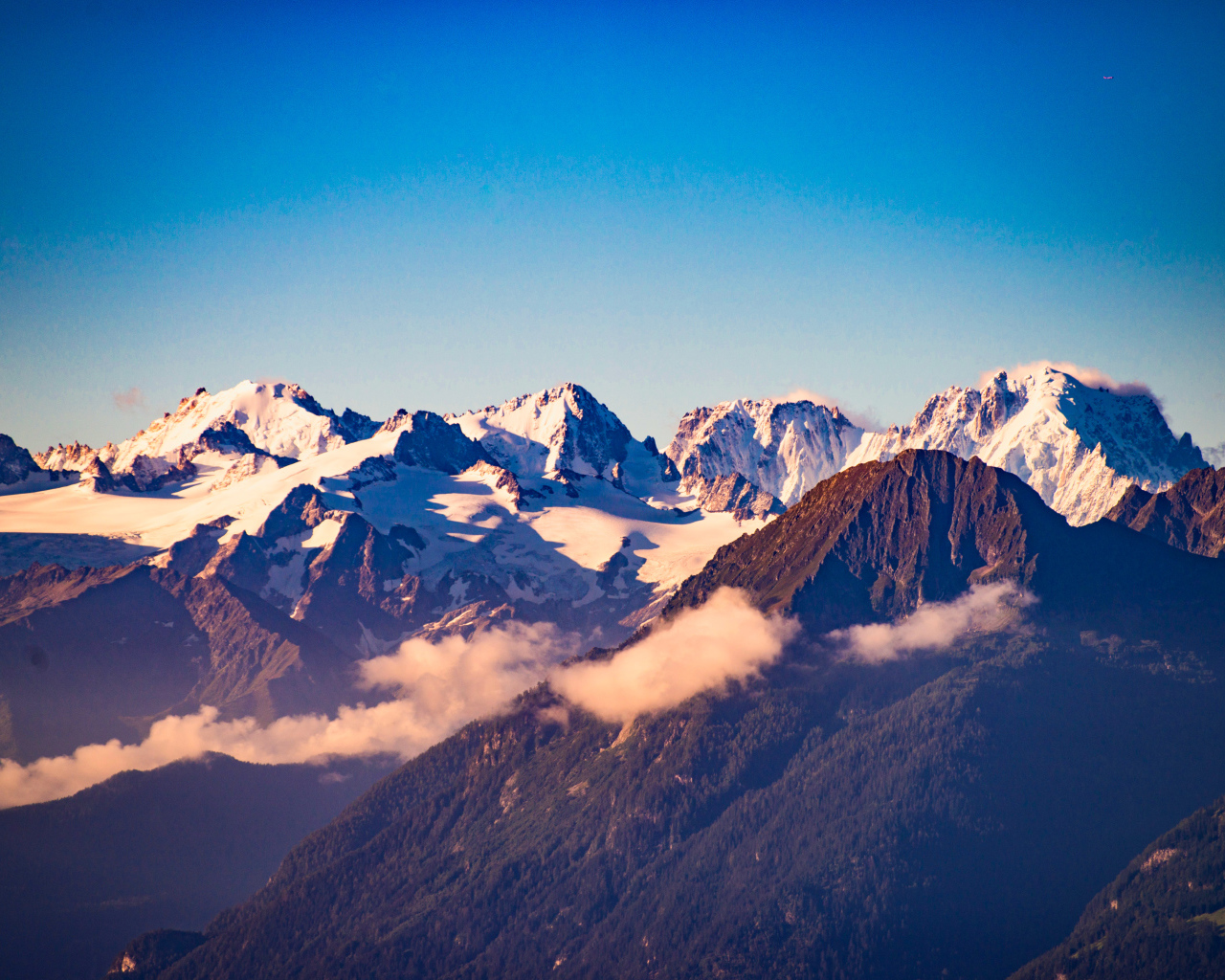 Заснеженные вершины гор под голубым небом